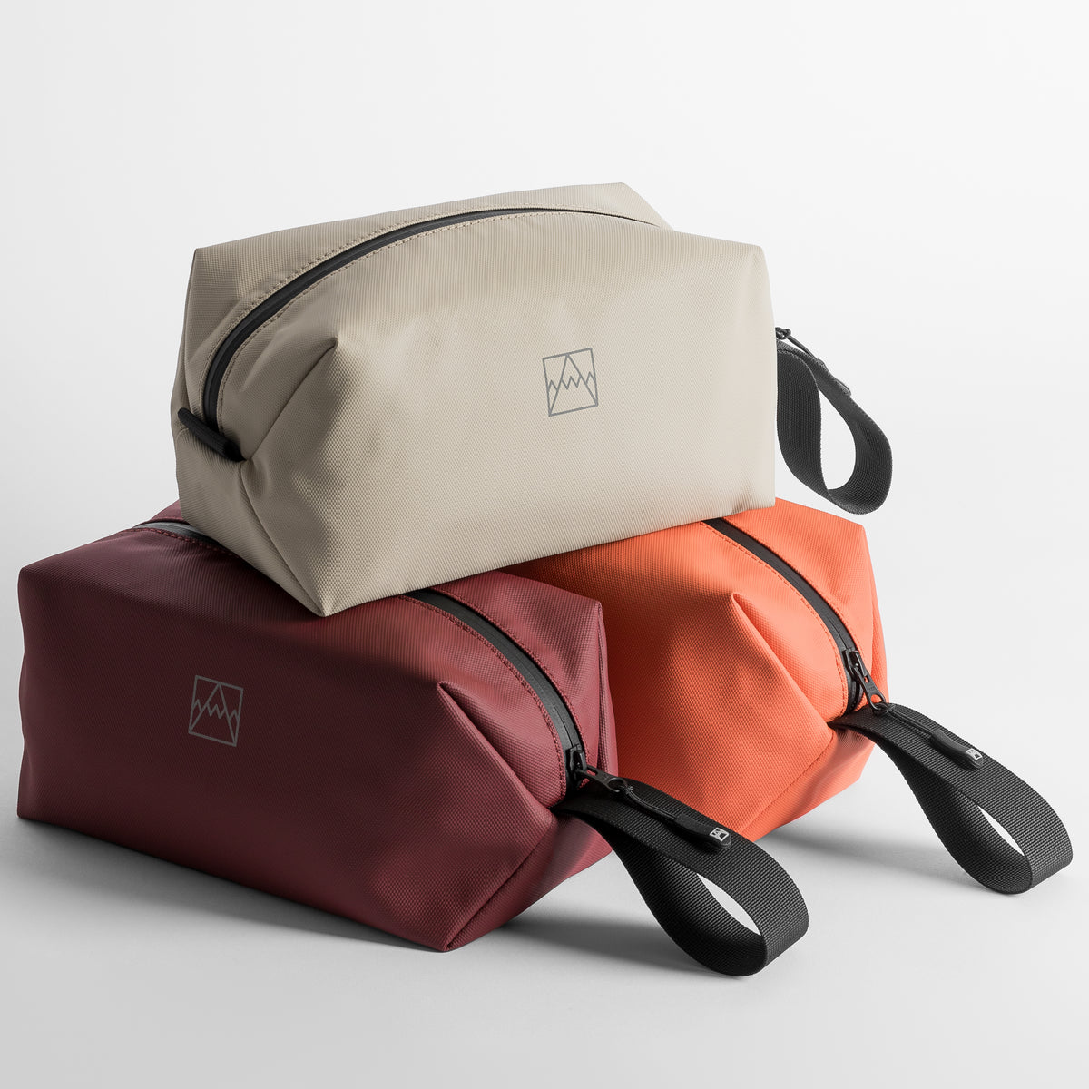Three Wash Bags stacked in Sand, Garnet Red and Rust