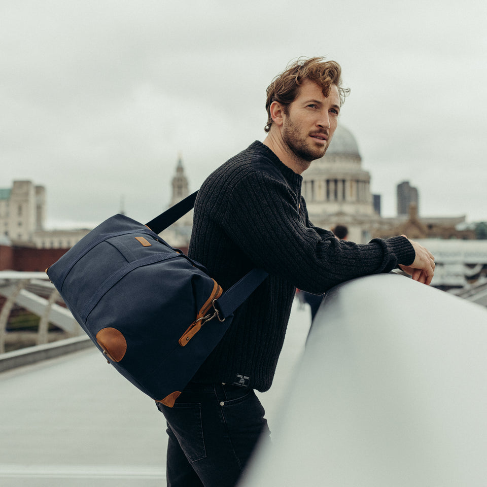 Man on a bridge with Weekender Duffle Bag
