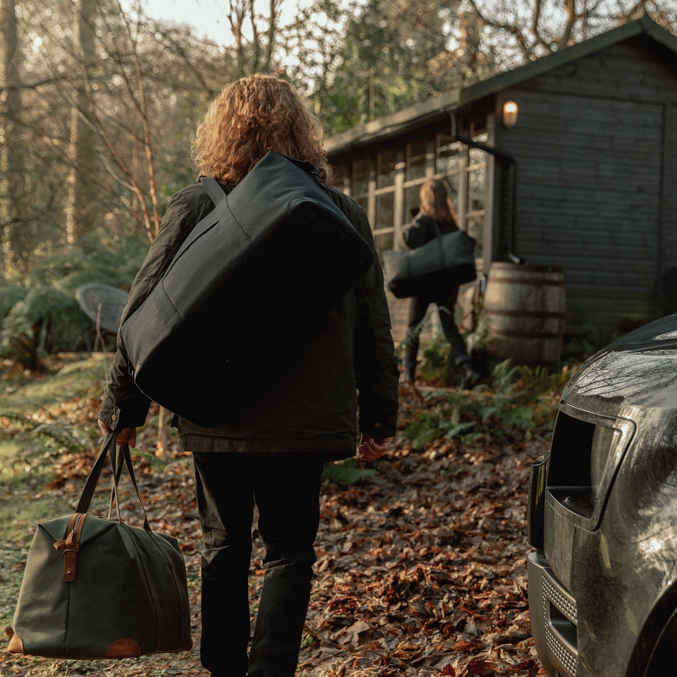 Man in woods with Weekender XL Duffle Bag