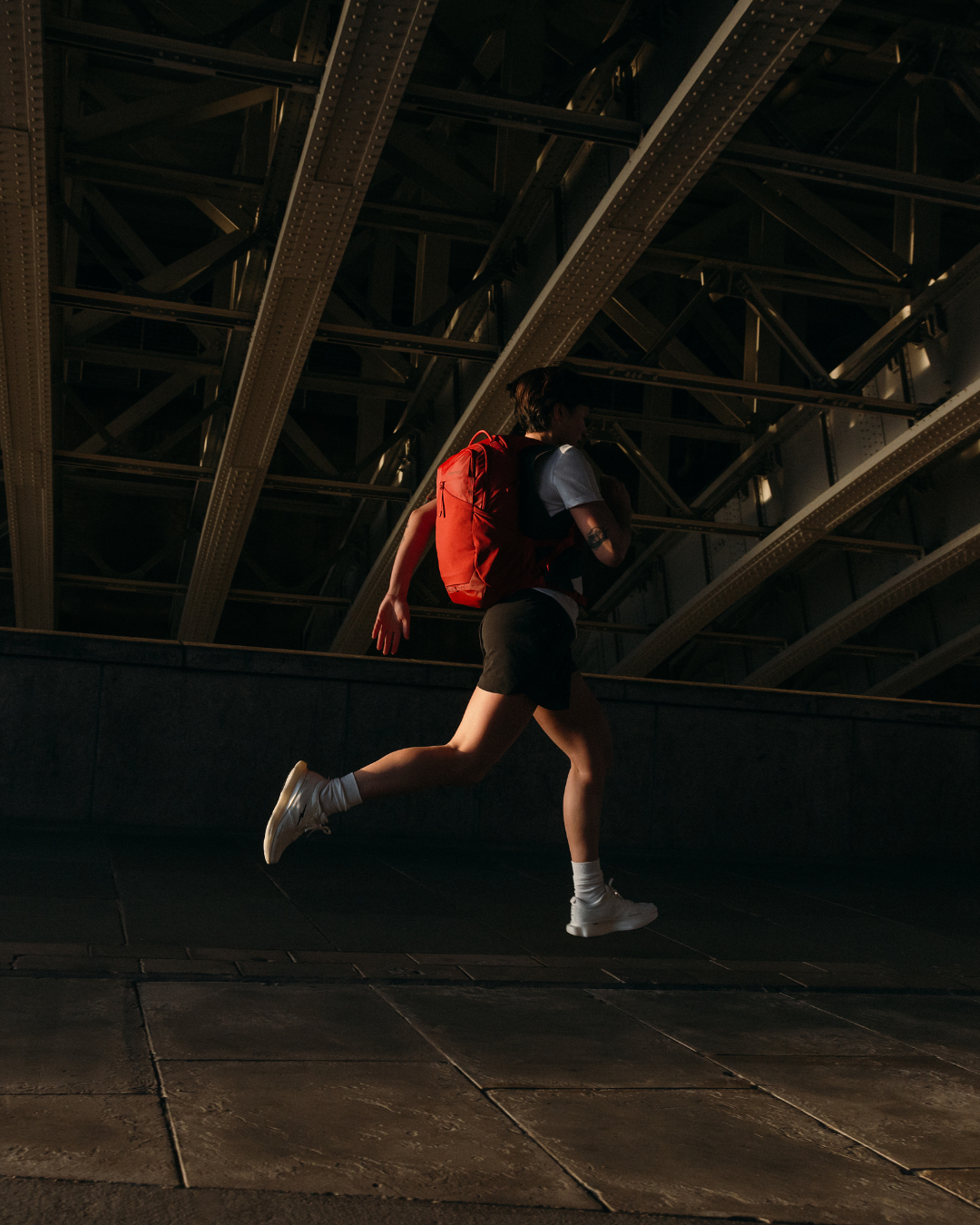 Woman wearing the Stubble & Co Motion Backpack whilst running under bypass in London