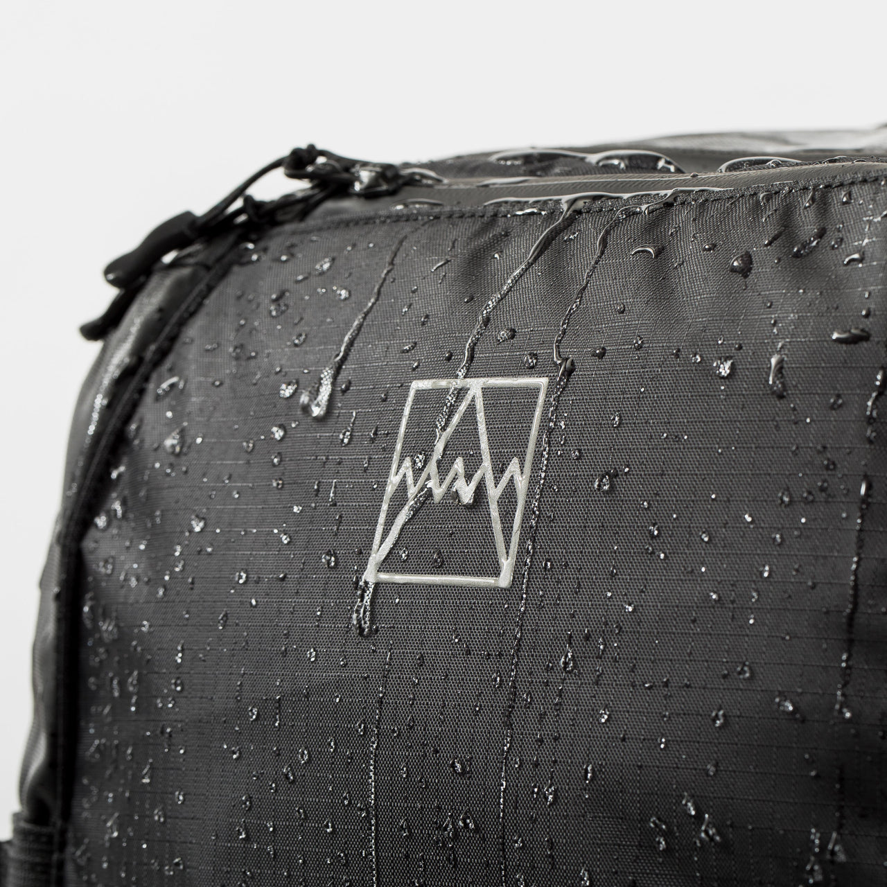 Adventure Bag in All Black close up with water drips