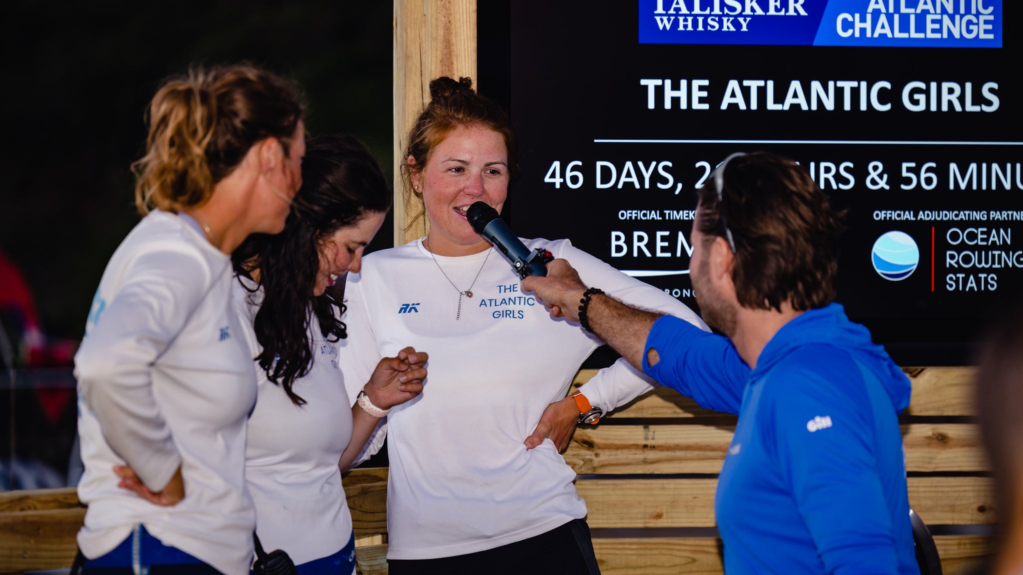 three woman being interviewed, wuth one woman talking into the microphone