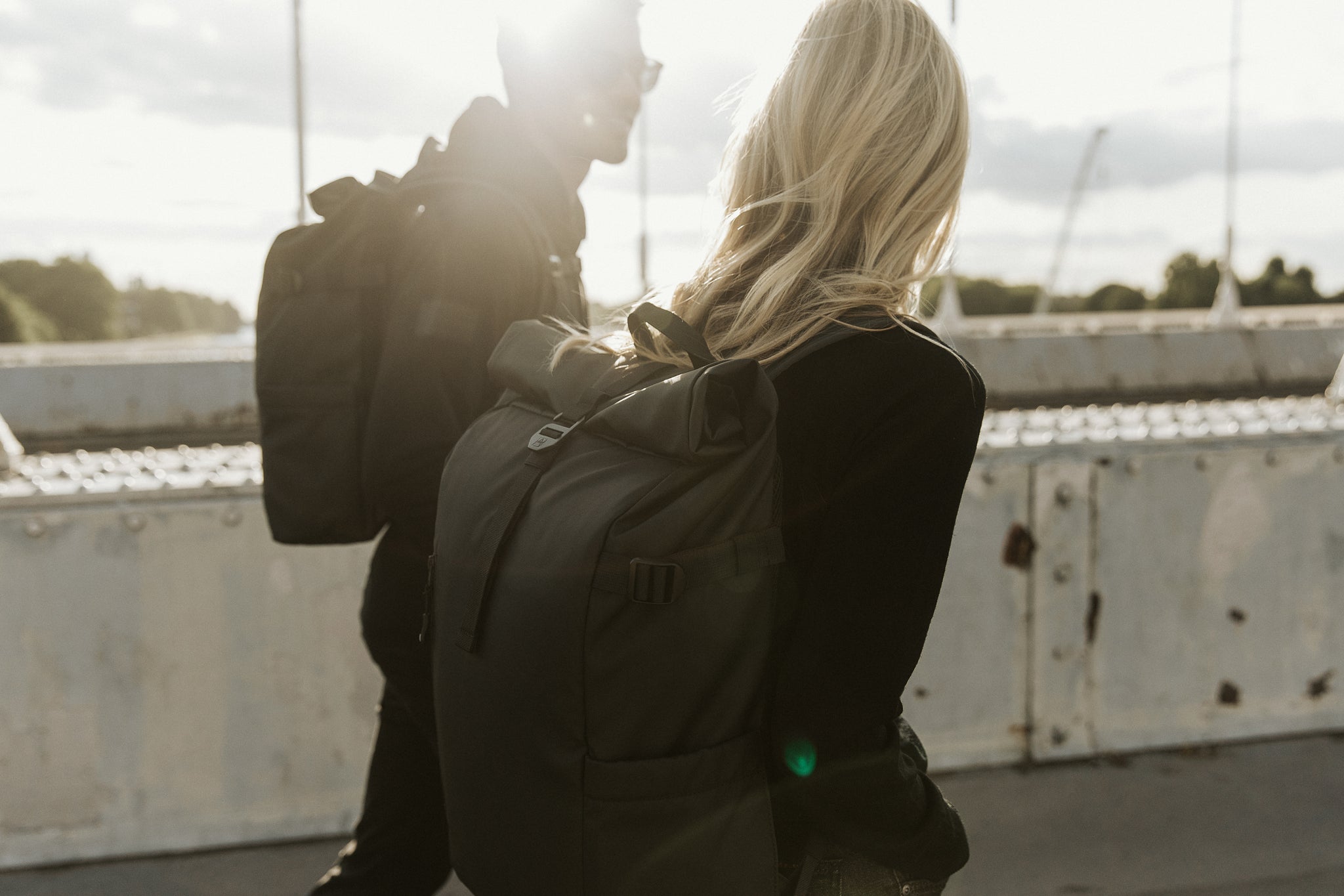 Two people wearing black backpacks