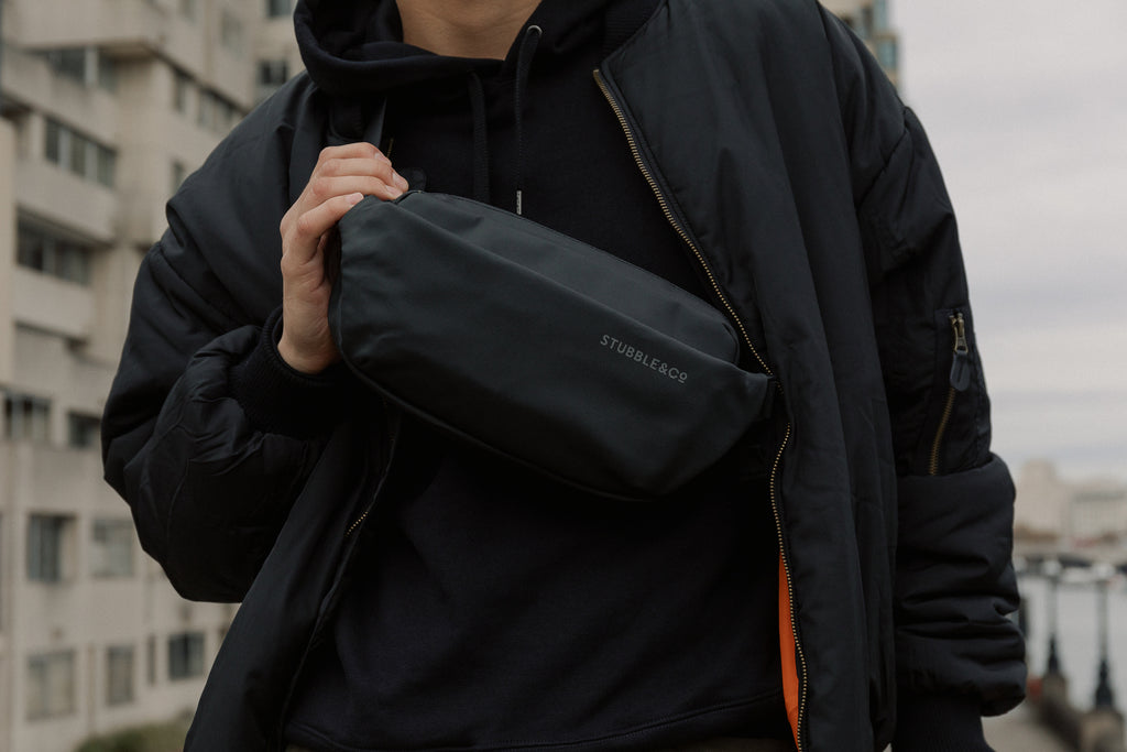 Close up view of a black crossbody bag on a person