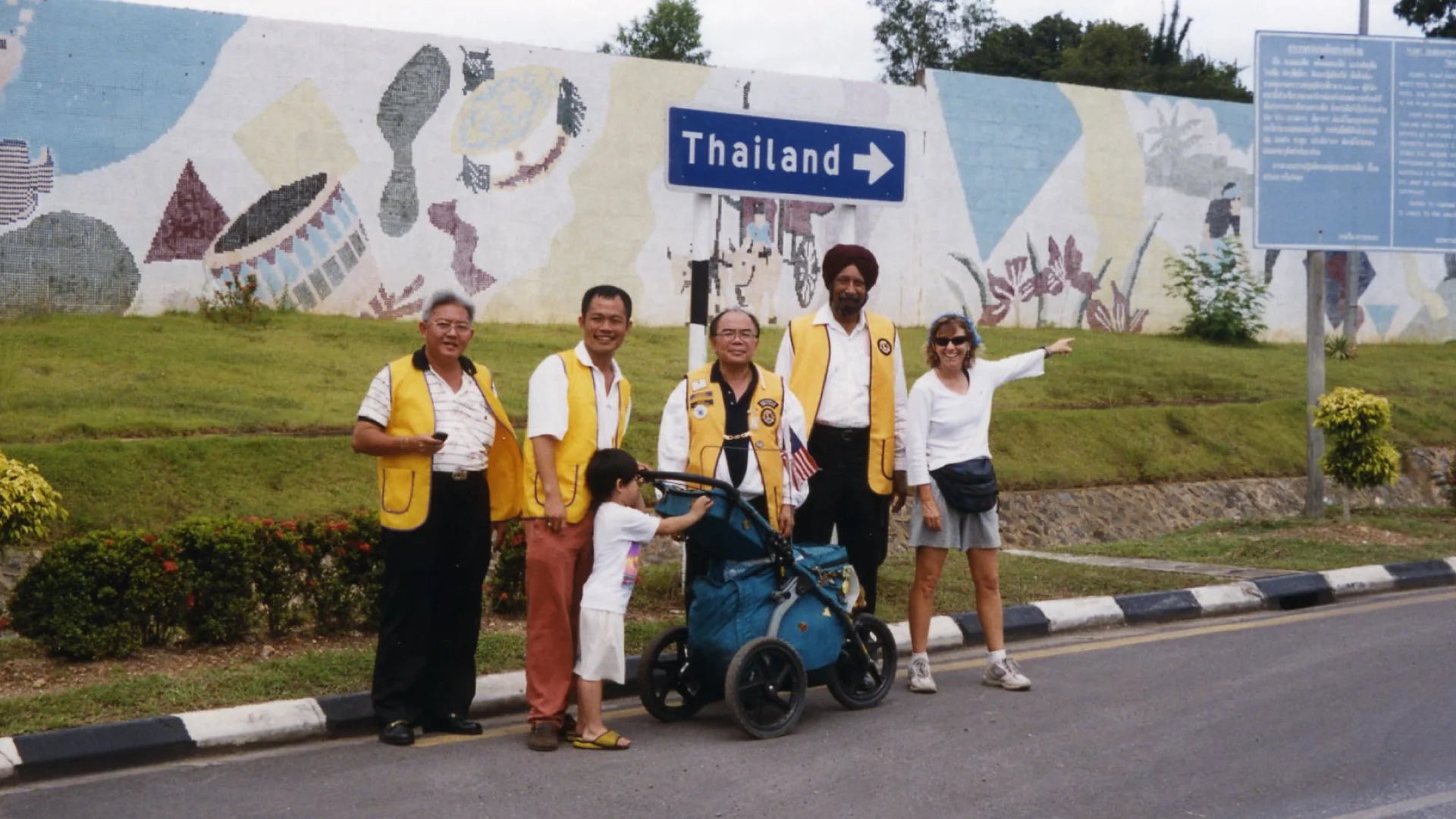 A woman standing with officials in Thailand