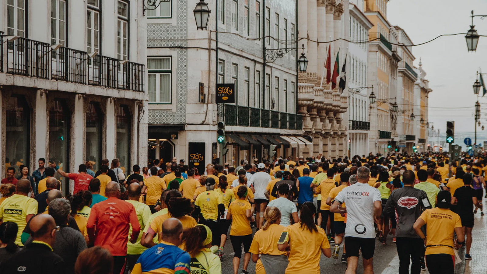 A crowd of people running through the streets of a city during a marathon