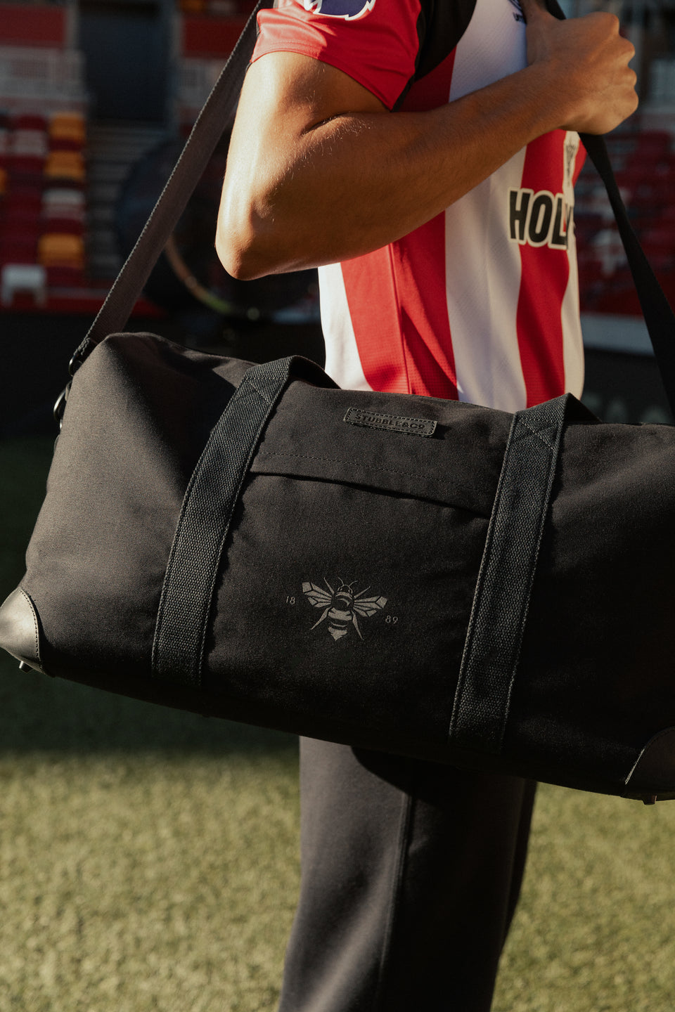 close up shot of black duffle bag on a man's shoulder