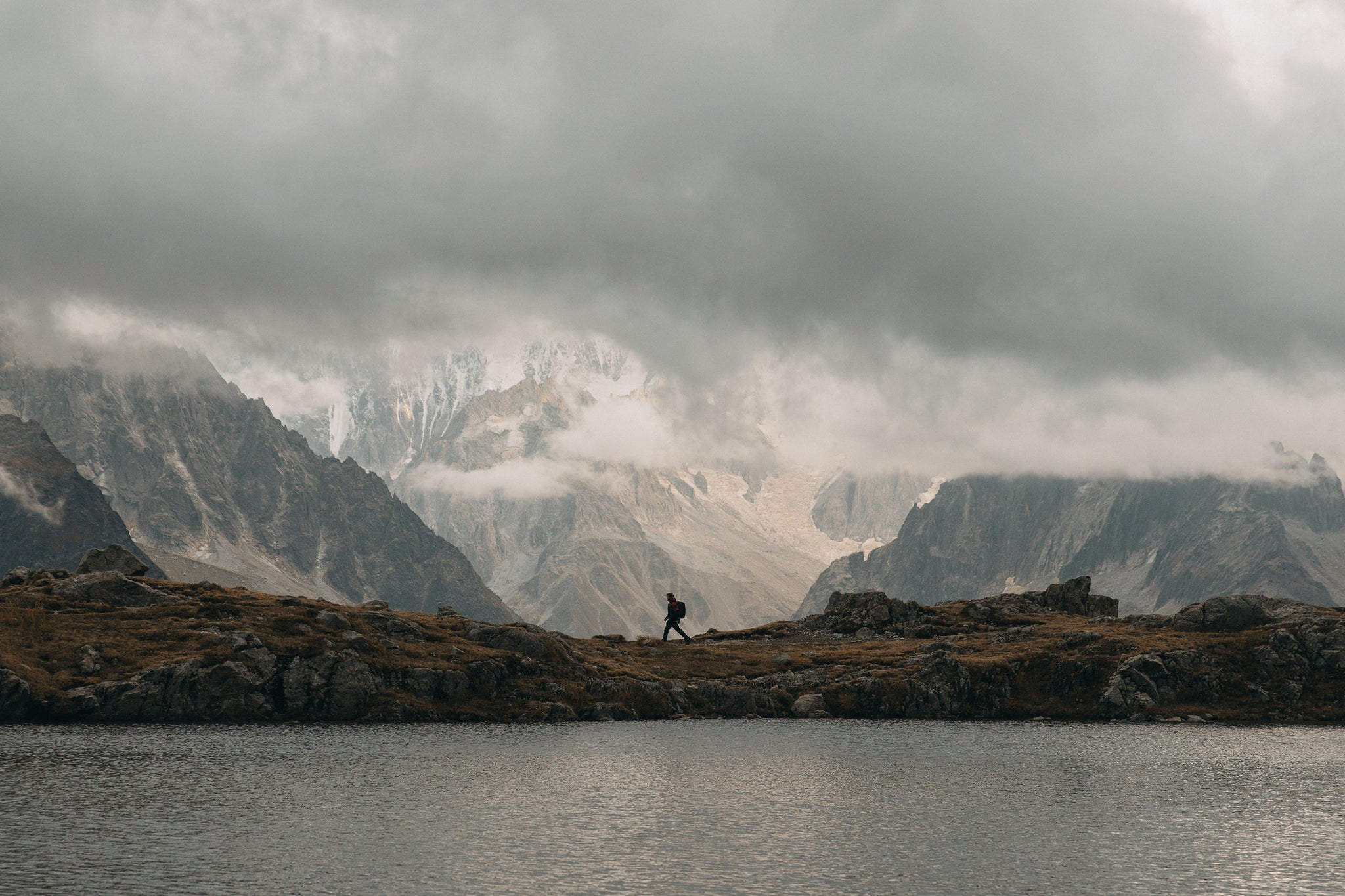 Man walking through mountains and lake