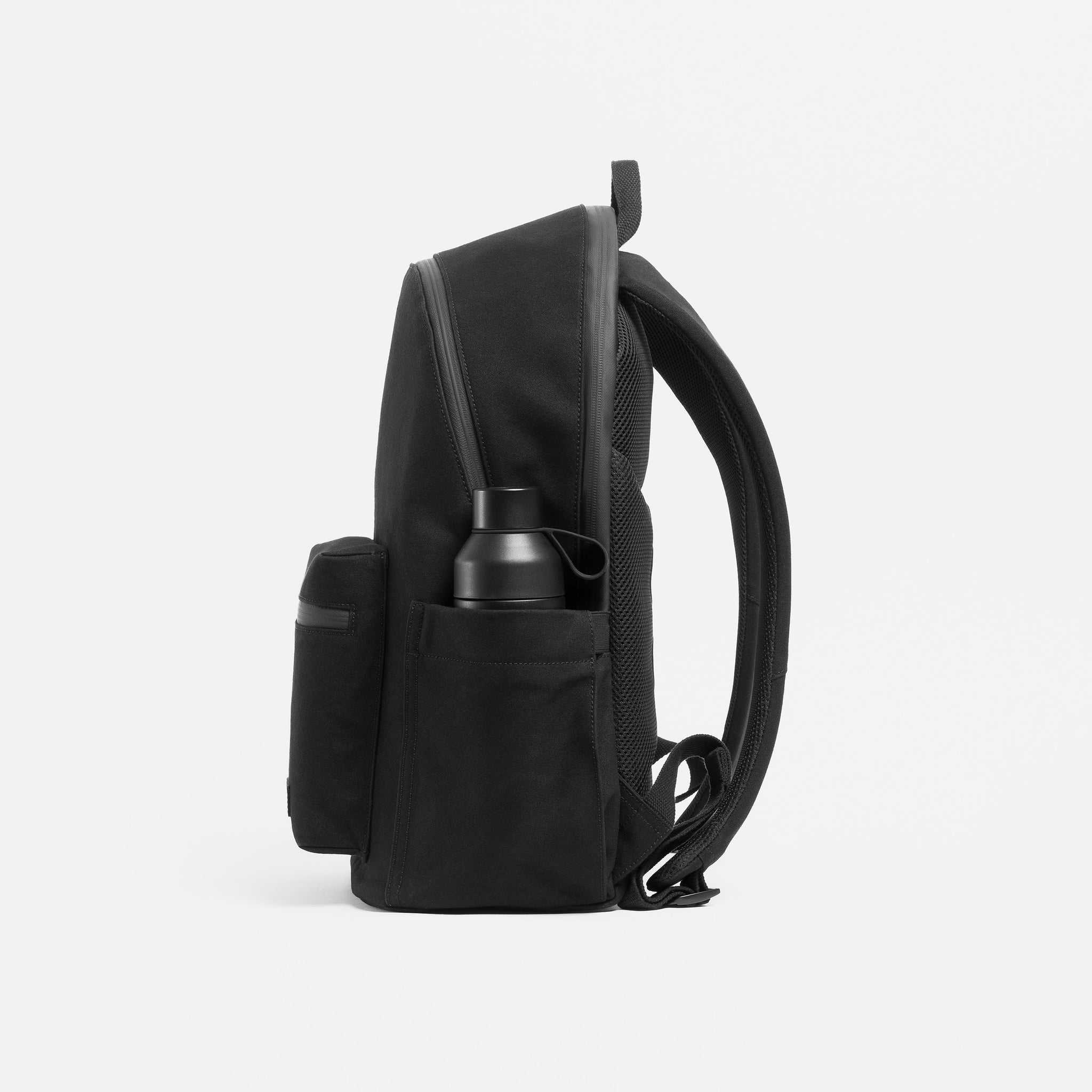 A studio shot of the side bottle pocket on the Commuter backpack 25L in All Black