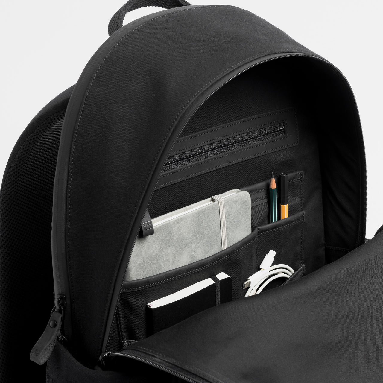 A studio shot of the interior pockets in the Commuter Backpack 25L in All Black