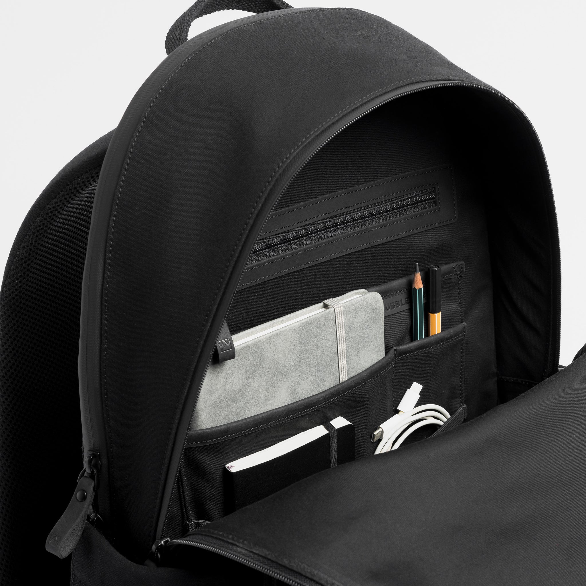 A studio shot of the interior pockets in the Commuter Backpack 25L in All Black