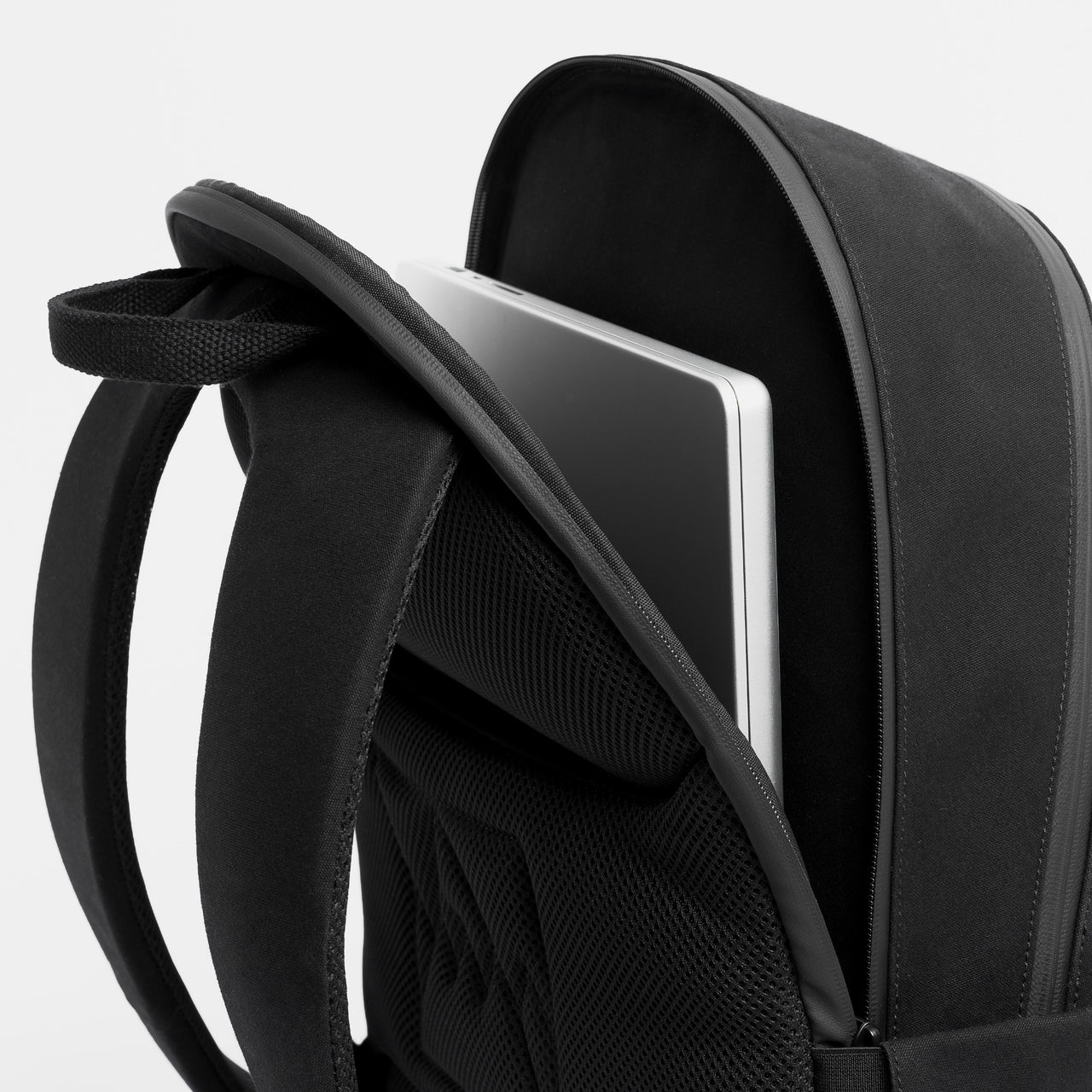 A studio shot of the laptop pocket on the Commuter Backpack 25L in All Black