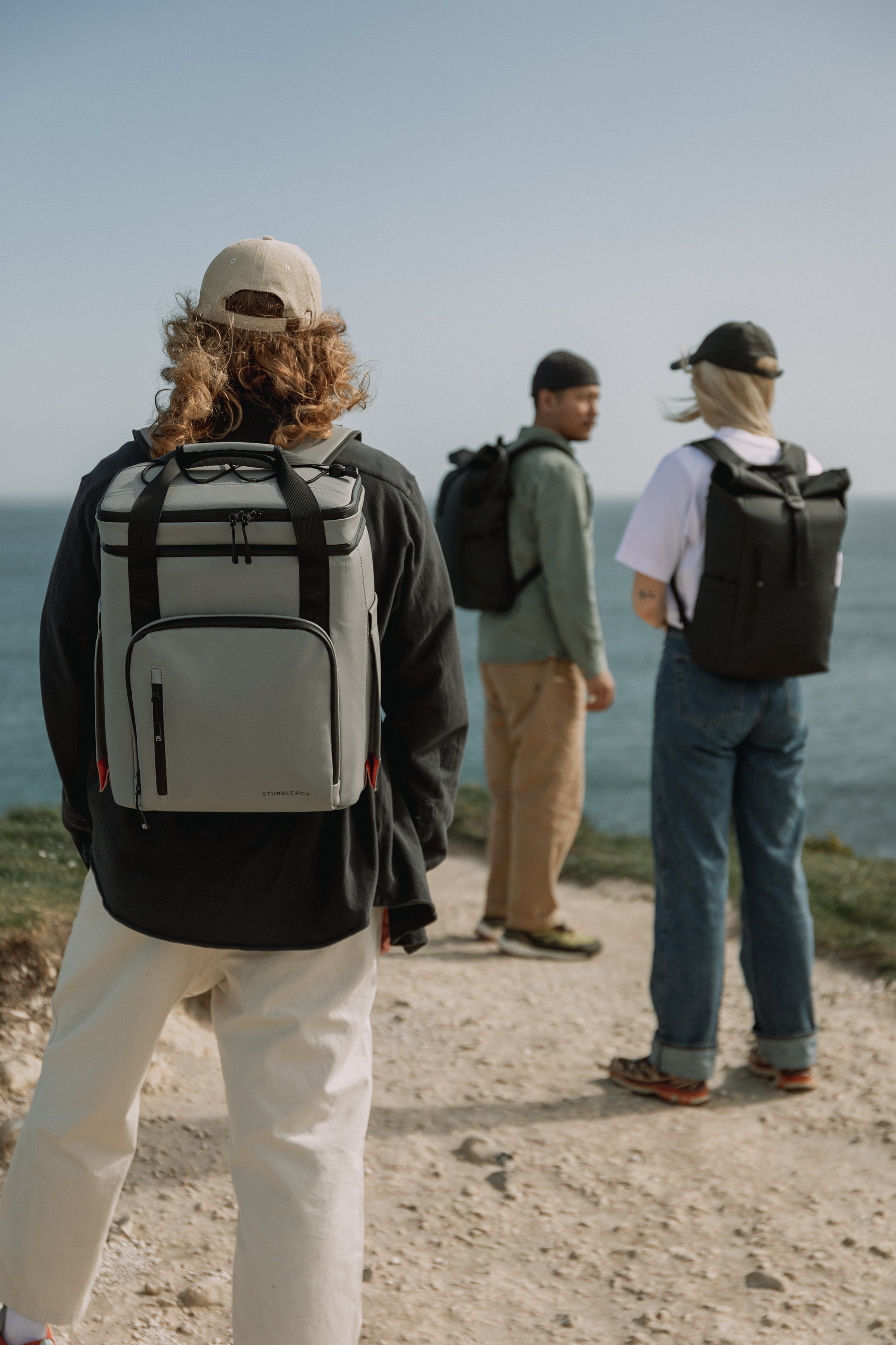 Group on a beach with The Cooler backpack