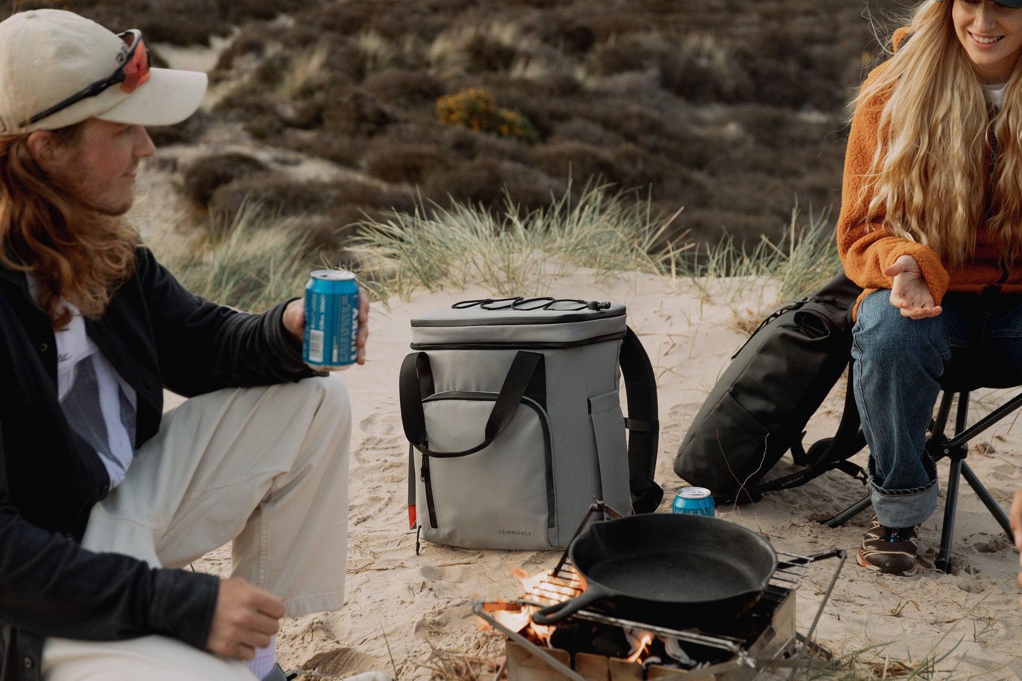 The Cooler backpack on a beach with people having picnic