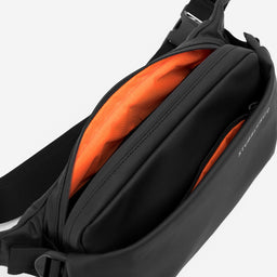A studio shot showing the interior orange lining of the All Black Crossbody