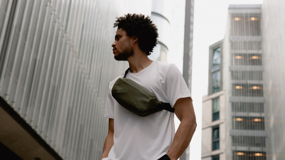 A man wearing a crossbody in urban green on his front