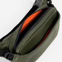 A studio shot of an Urban Green Crossbody showing the interior orange lining and front pockets