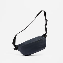 A studio shot of the Midnight Blue Crossbody hanging from its strap