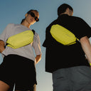 A man and woman in the sun wearing Volt Crossbody 