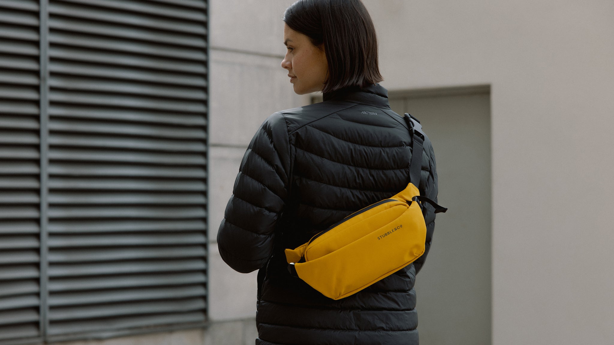 A woman wearing a yellow crossbody on her back