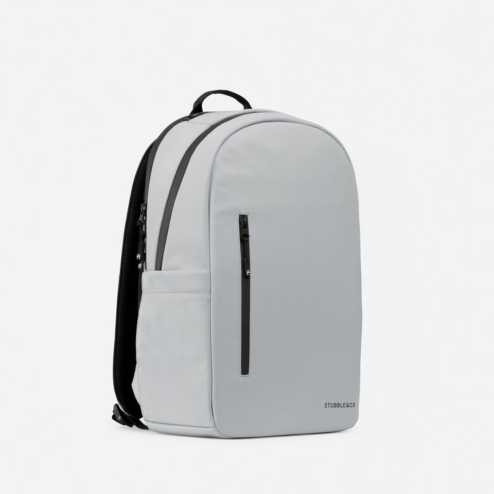 A studio shot of the Everyday Backpack 20L in Concrete at an angle showing the front and the side of the backpack