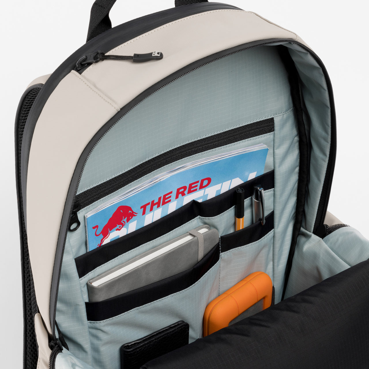 A studio shot of the interior organisation and blue lining of the Everyday Backpack 20L in Sand 