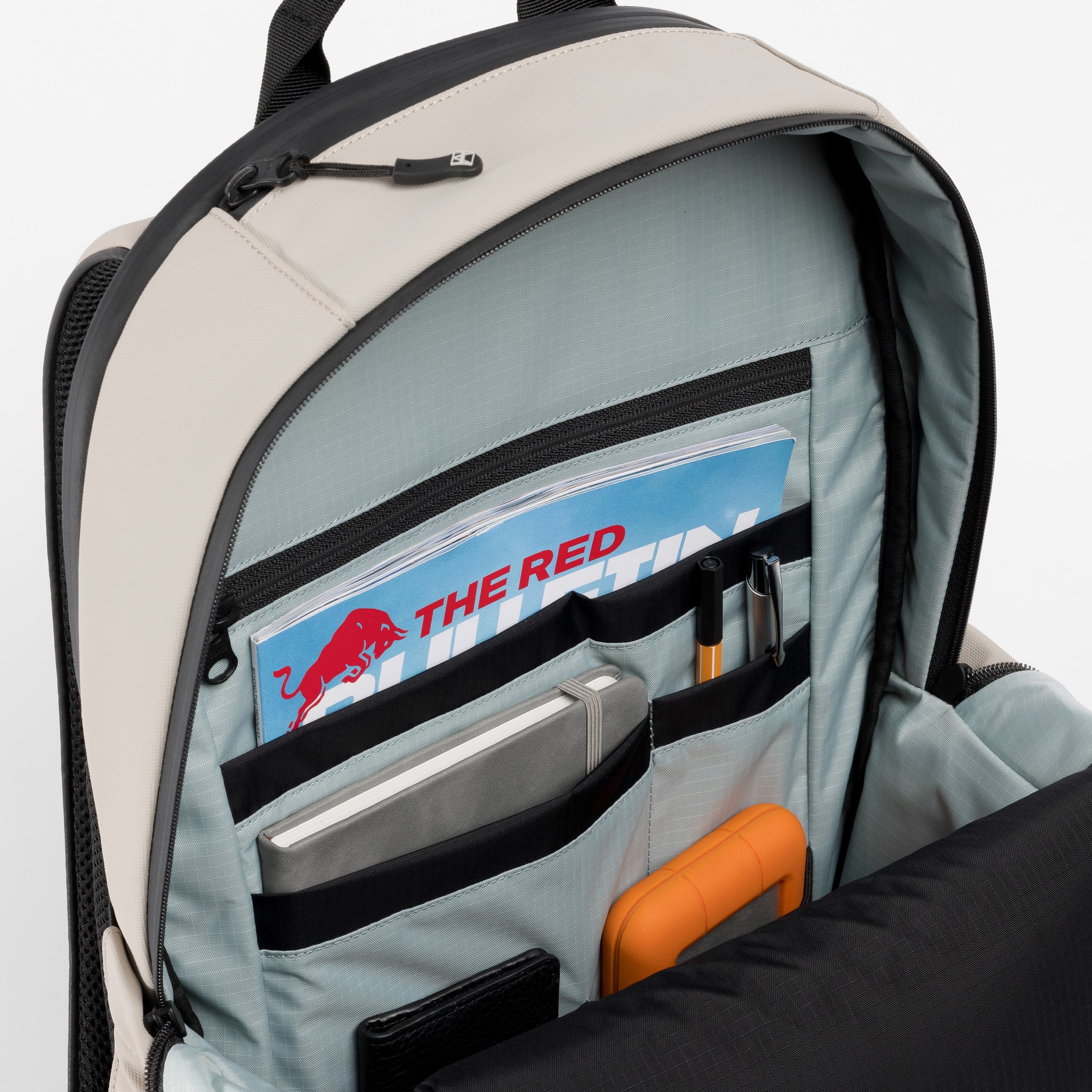 A studio shot of the interior organisation and blue lining of the Everyday Backpack 20L in Sand 