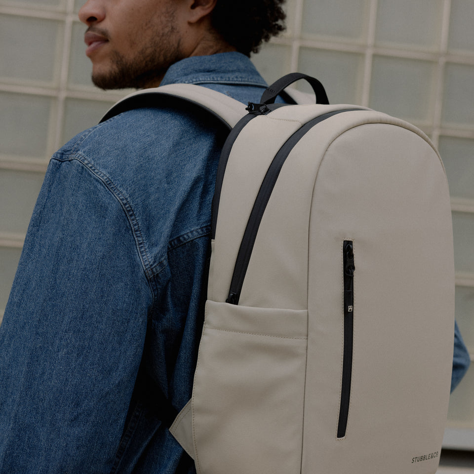 A close up of the Everyday Backpack 20L in Sand on a mans back