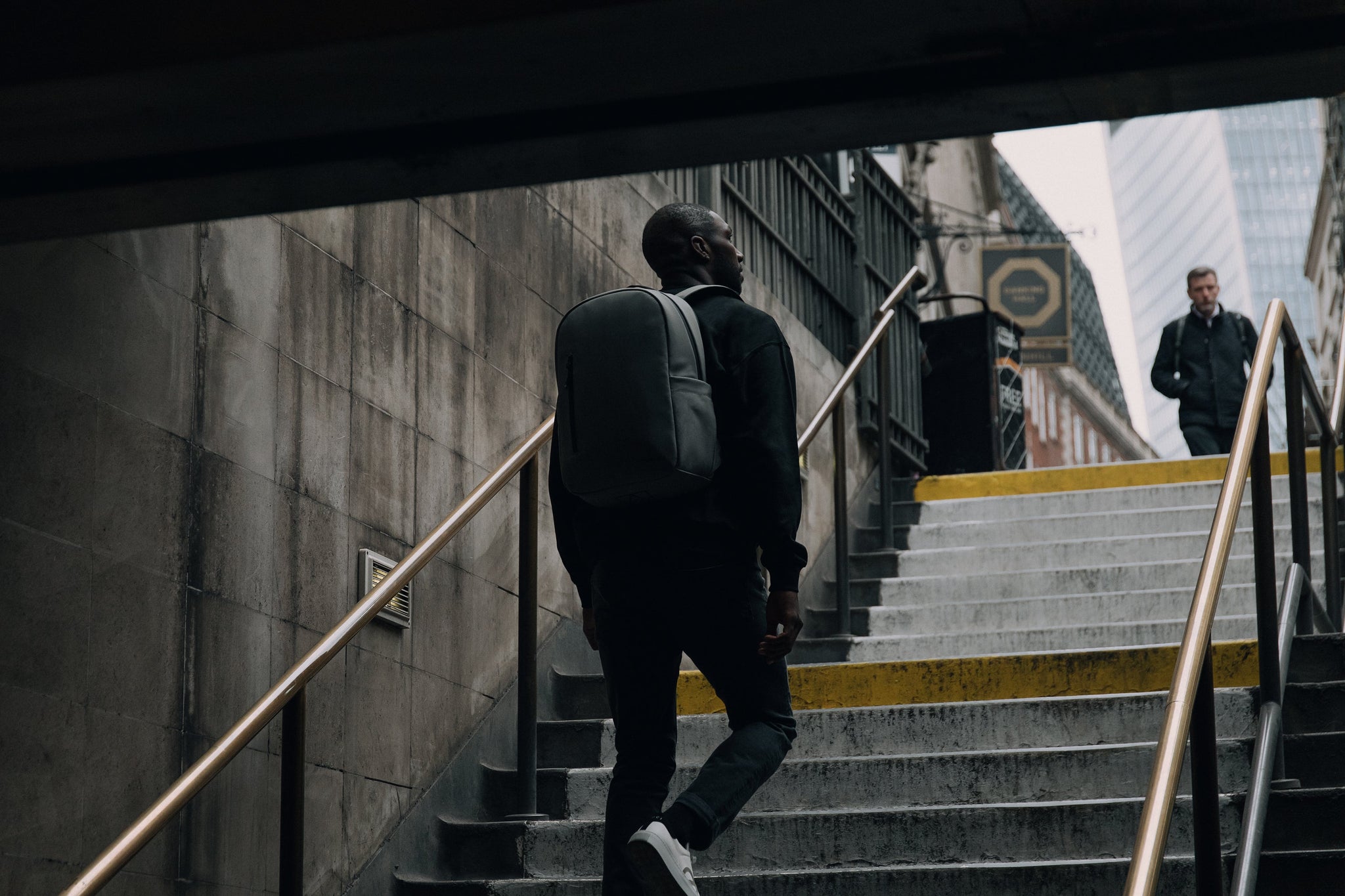 Man wearing everyday backpack walking up steps
