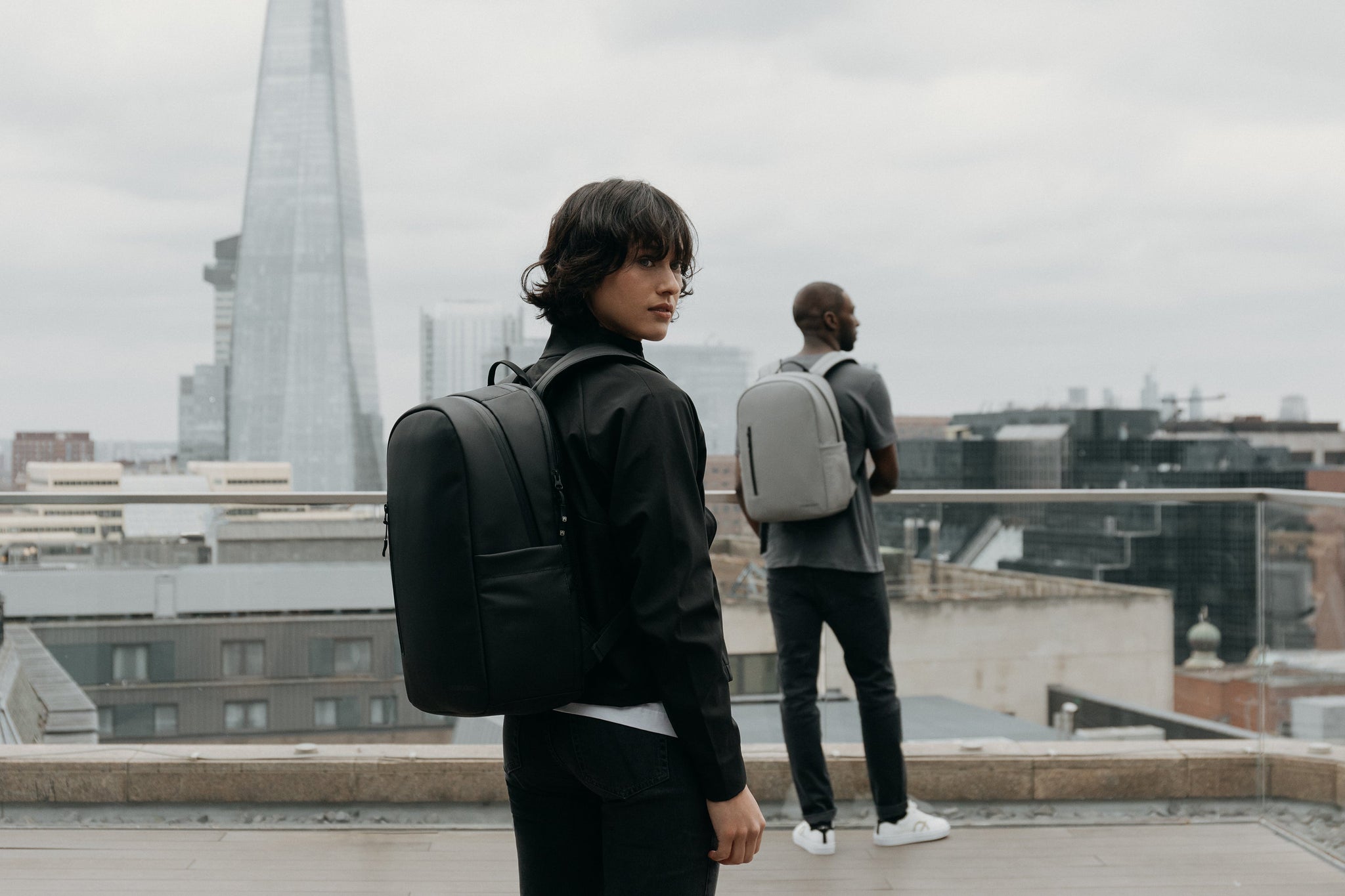 Women with black backpack and a man standing behind