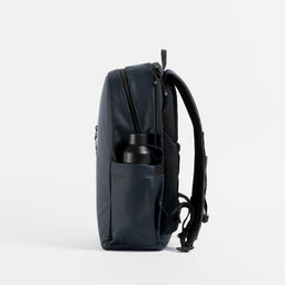 A studio shot of a bottle in the side bottle pocket on an Everyday Backpack in Midnight Blue