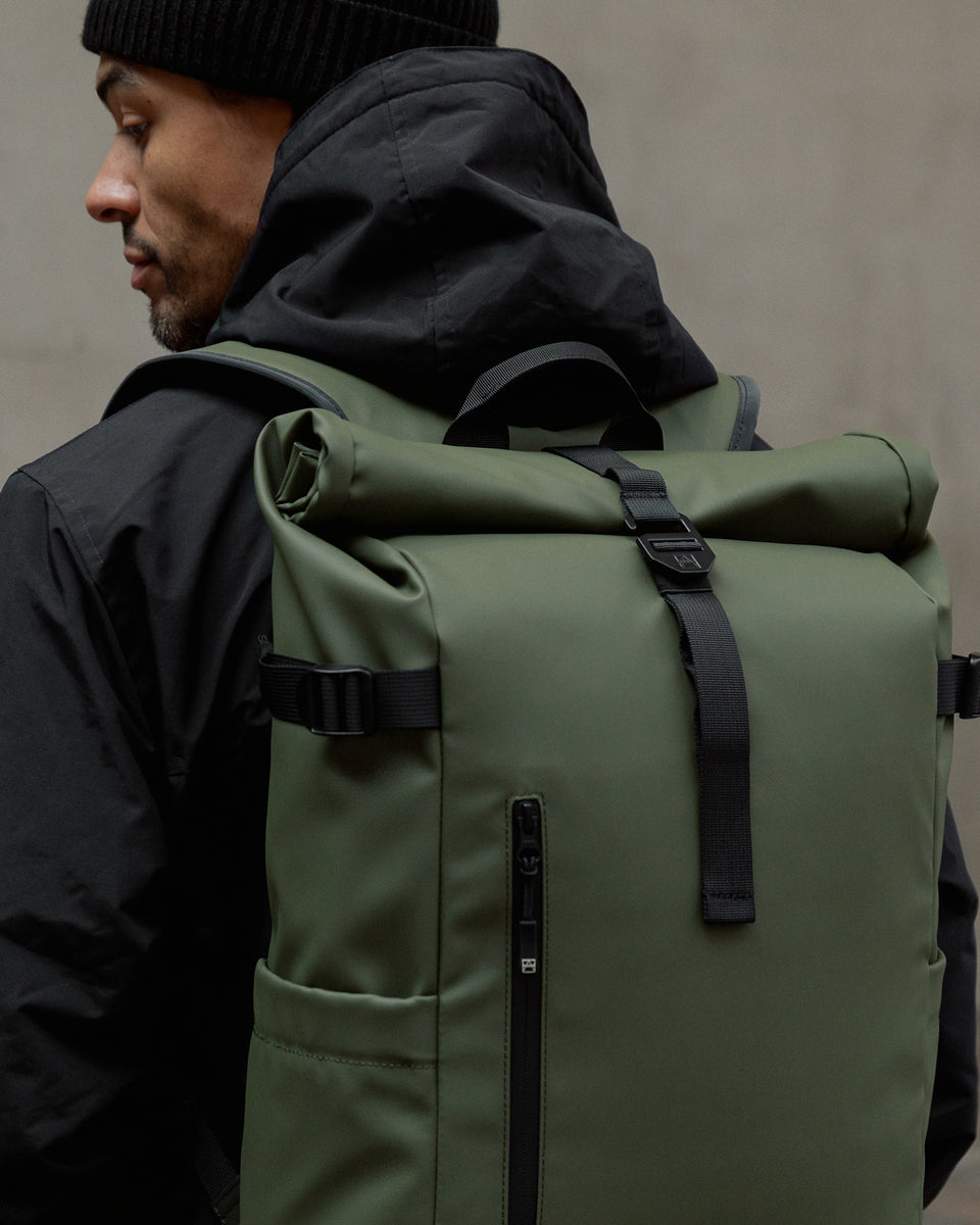 a close up of an urban green roll top on a man's back