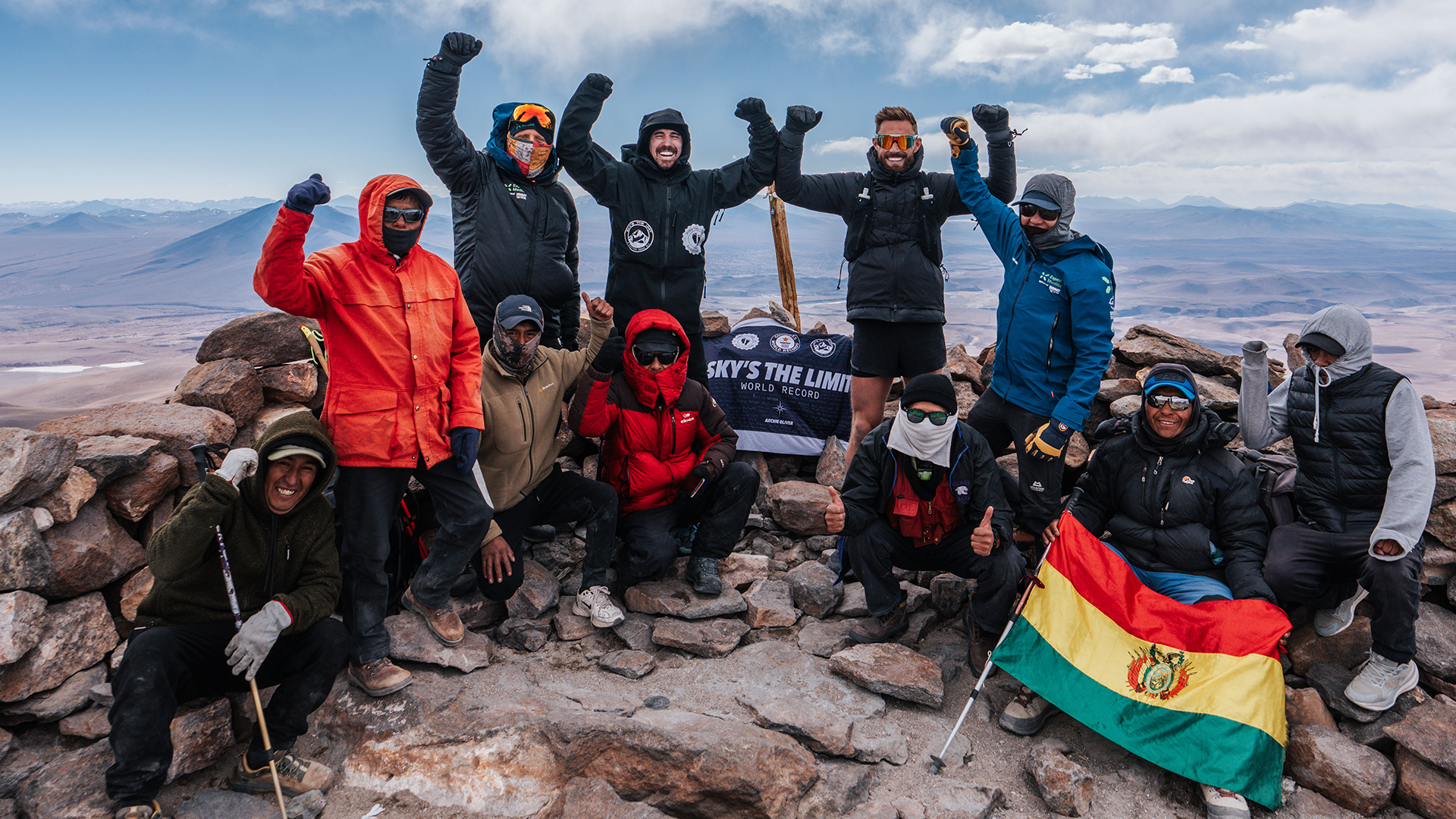 Group of people celebrating on top of a mountain in Bolivia after breaking World Record