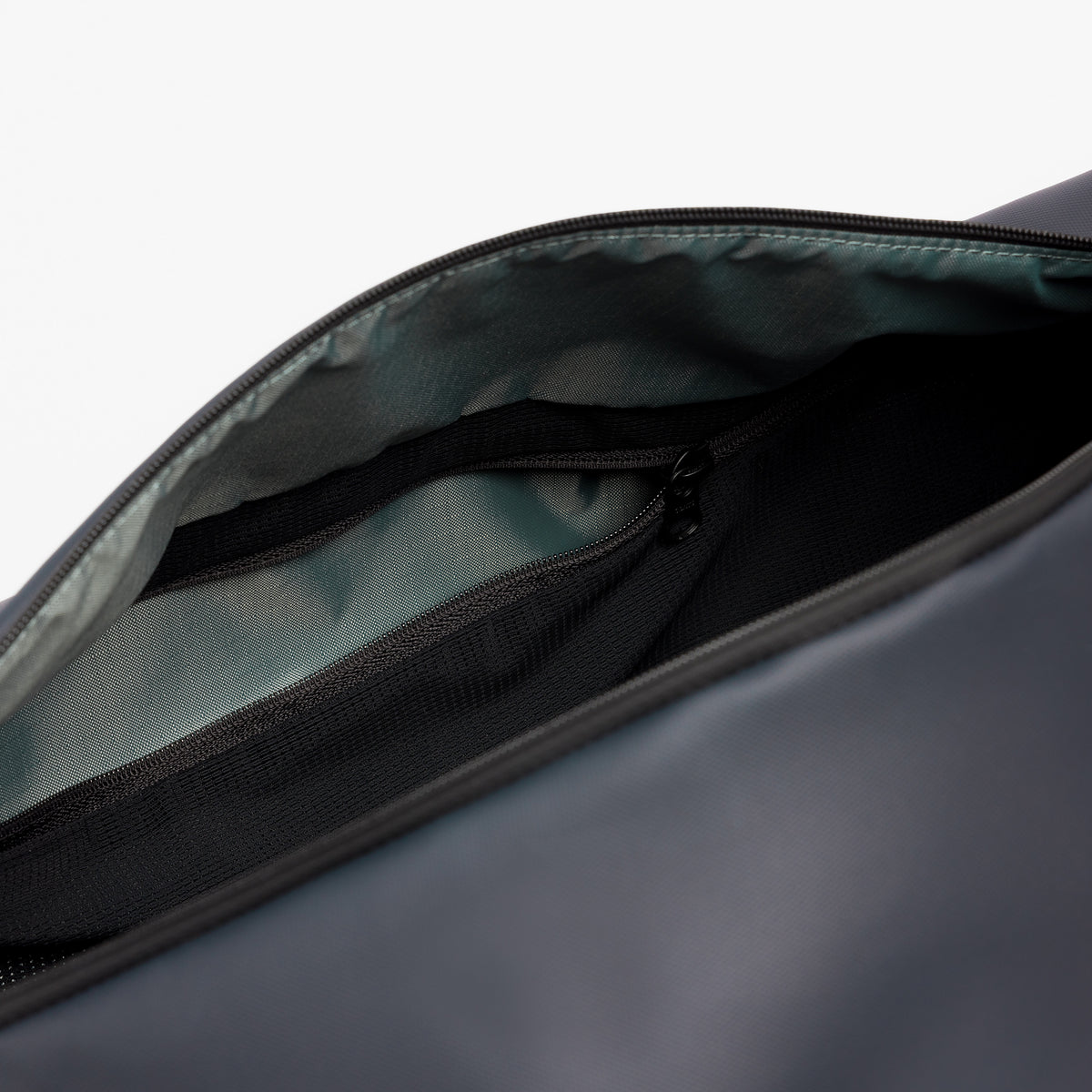 A studio shot of a close up of the interio zipped pocket on the Midnight Blue Gym Duffel 25L