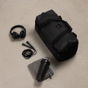 A studio shot of the gym duffel 25l in All Black with the content around including a skipping rope, headphones and towel