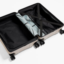 A studio shot of the inside and compression strap in the Hardshell 95L in Sand