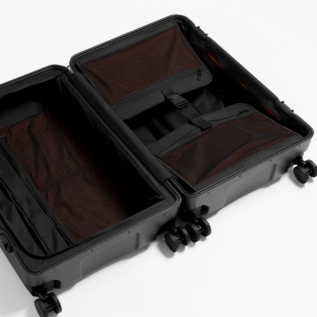 An open black hard-shell suitcase on a white background, showing orange interior organizer pockets and compartments.