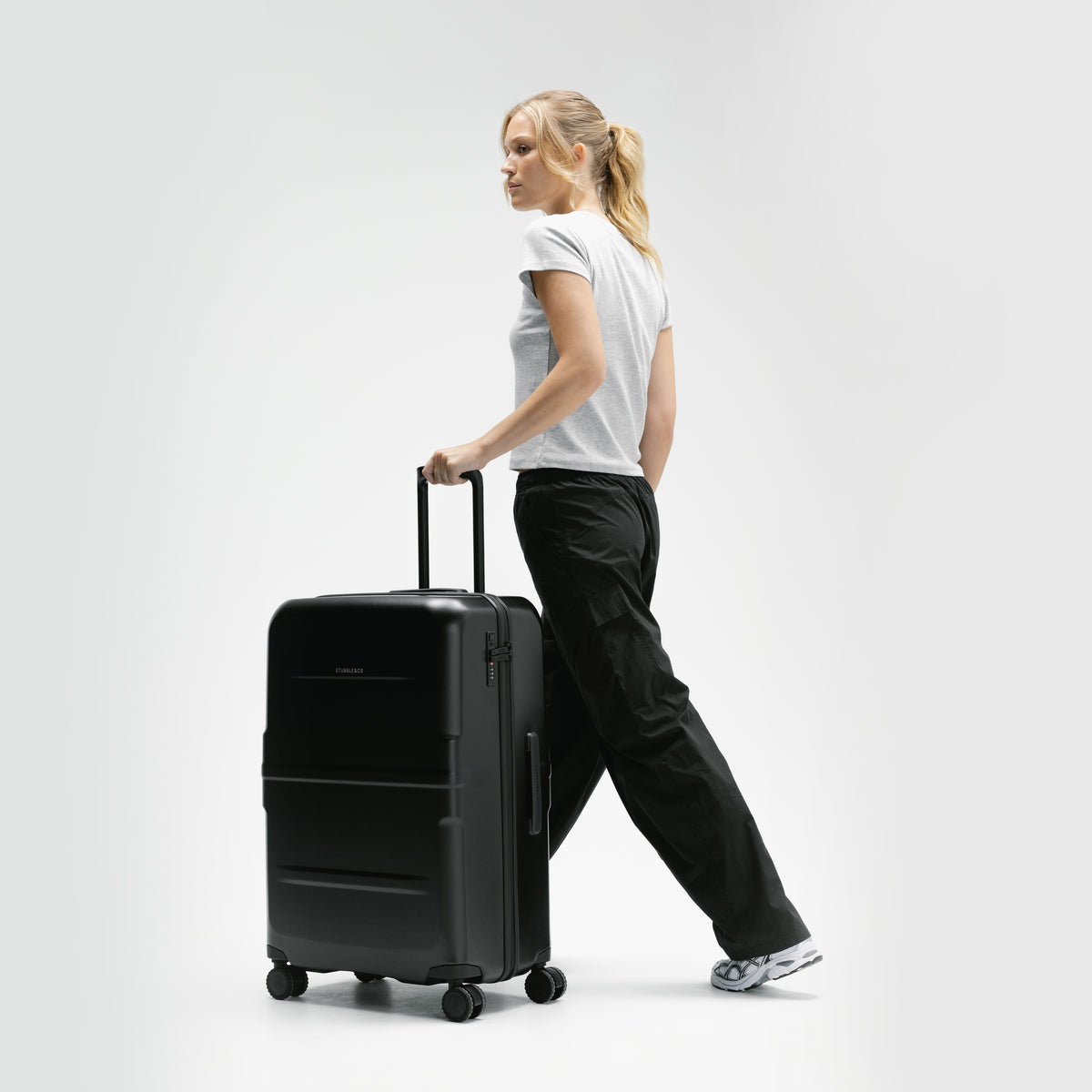 A female model walking with the Hardshell 95L in All Black