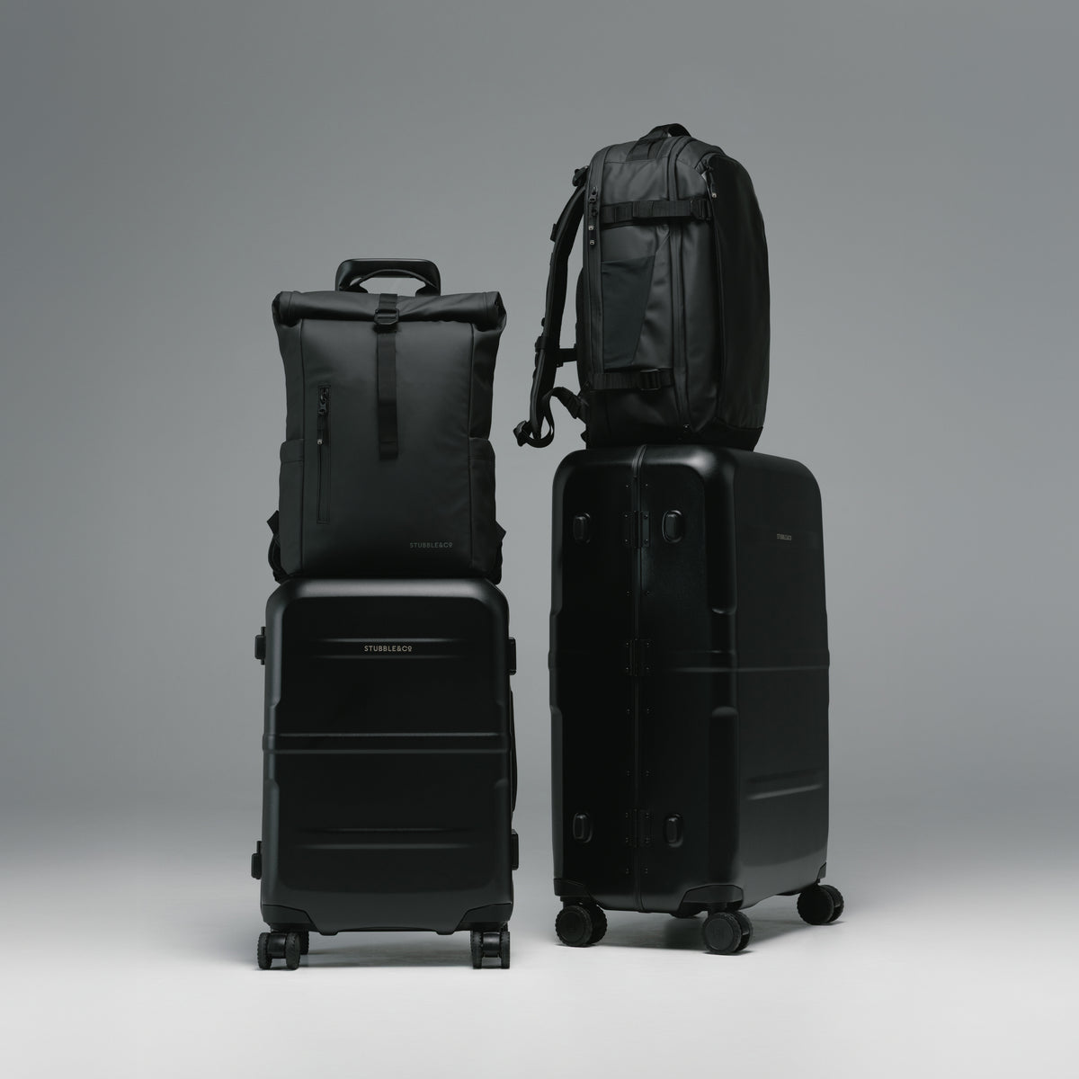 A studio shot of the Hardshell Pro range in All Black with the Roll Top and Hybrid Backpack on the trolley sleeve