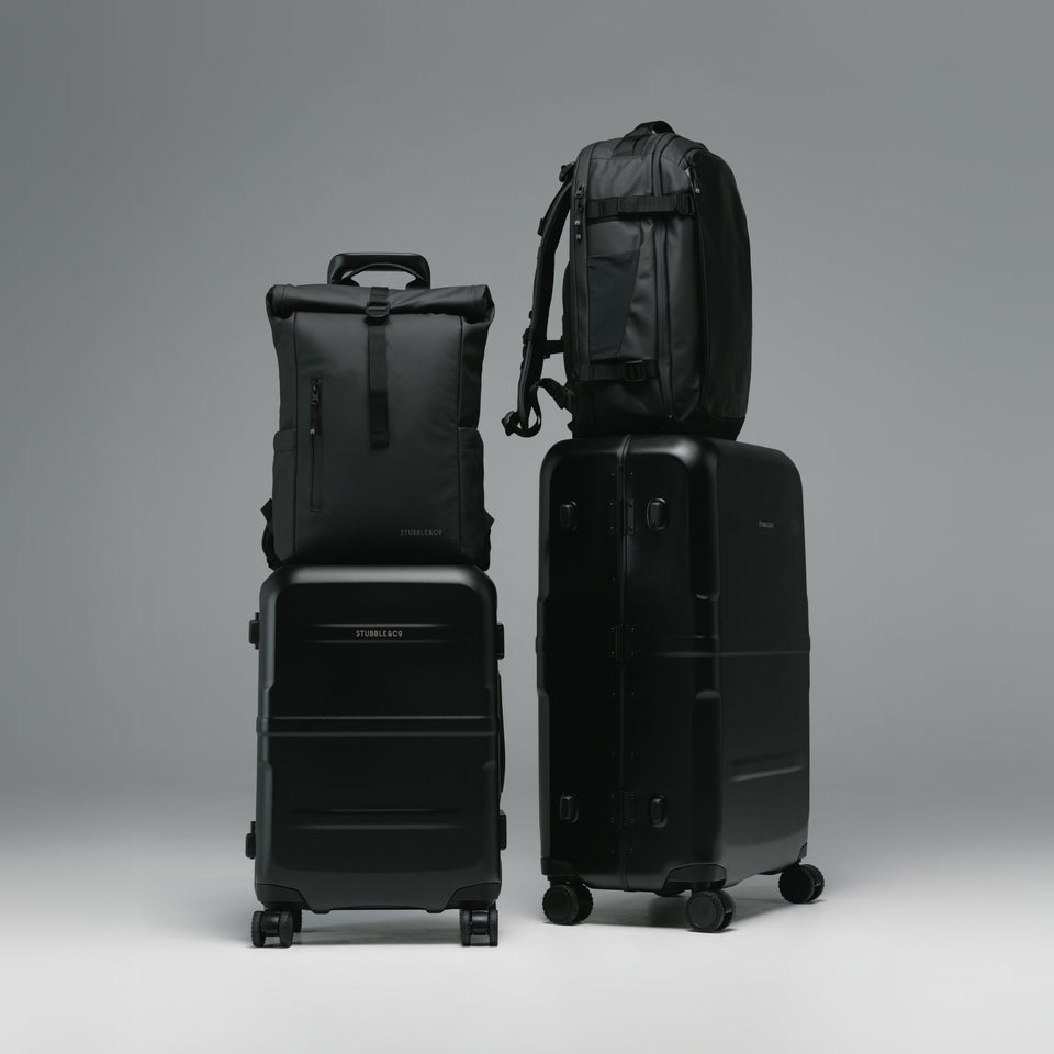 A studio shot of the Hardshell Pro range in All Black with the Roll Top and Hybrid Backpack on the trolley sleeve