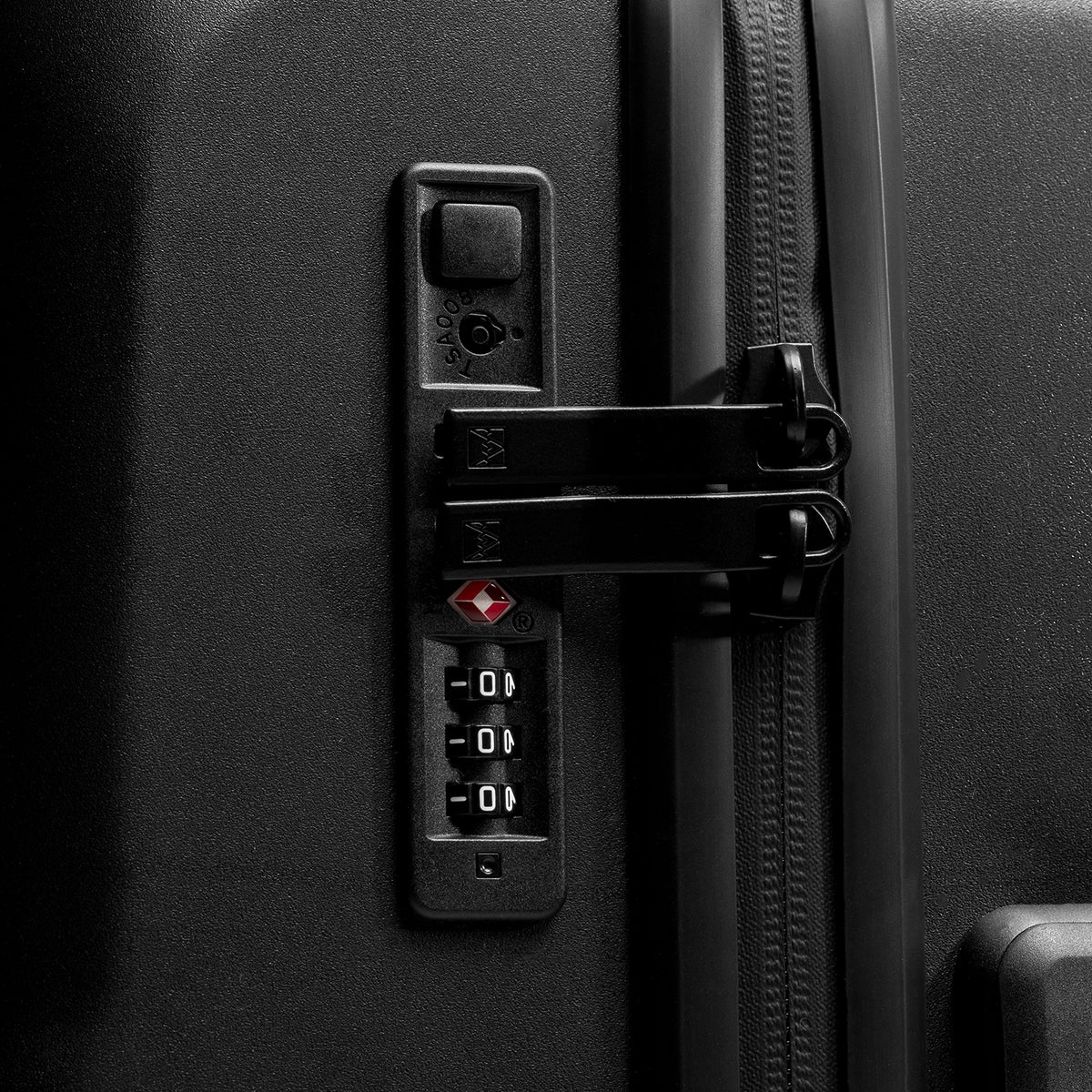 Close-up of a black hard-shell suitcase showing the tsa lock mechanism, including a triple-digit combination lock.