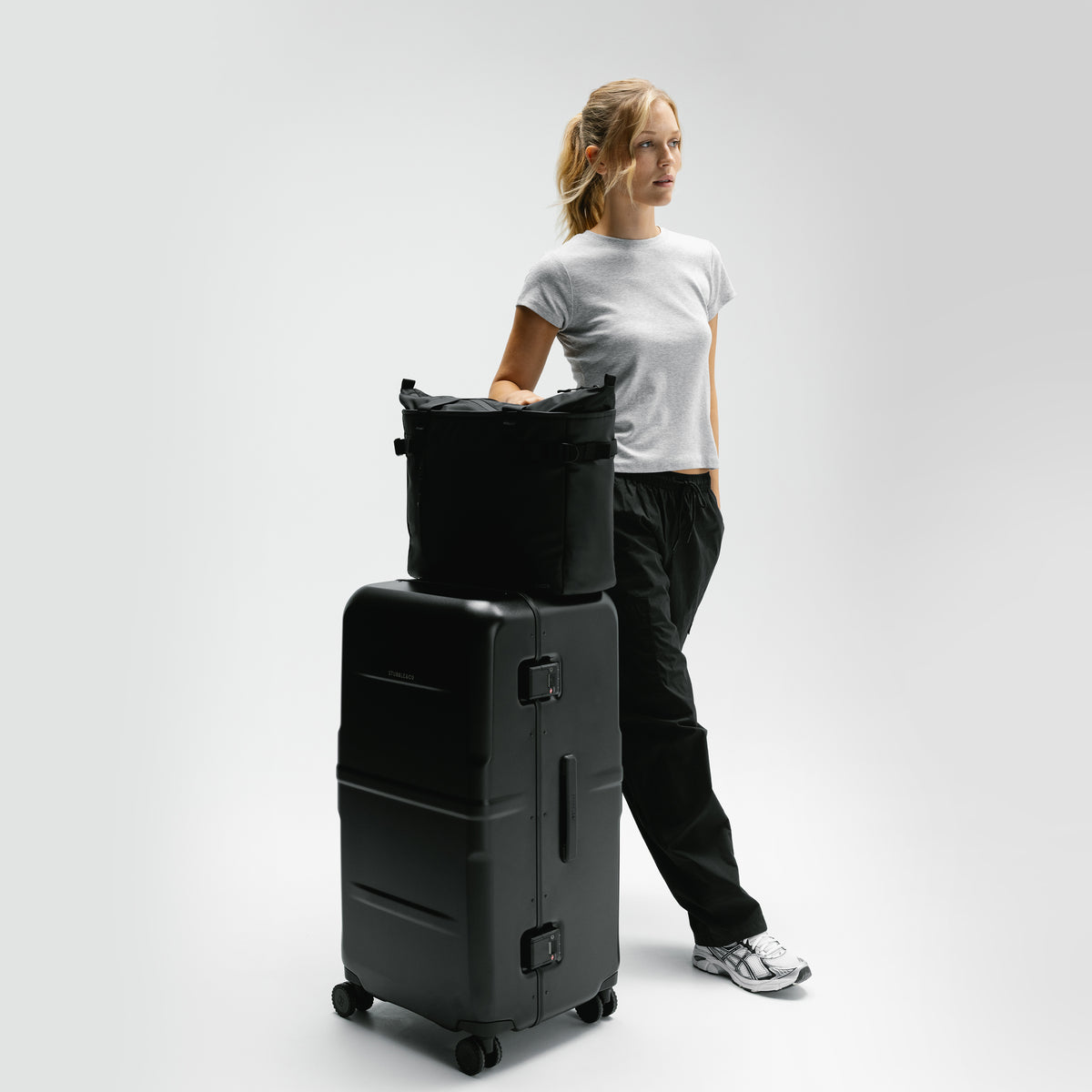 A womn with the Hardshell Pro Trunk 100L in All Black