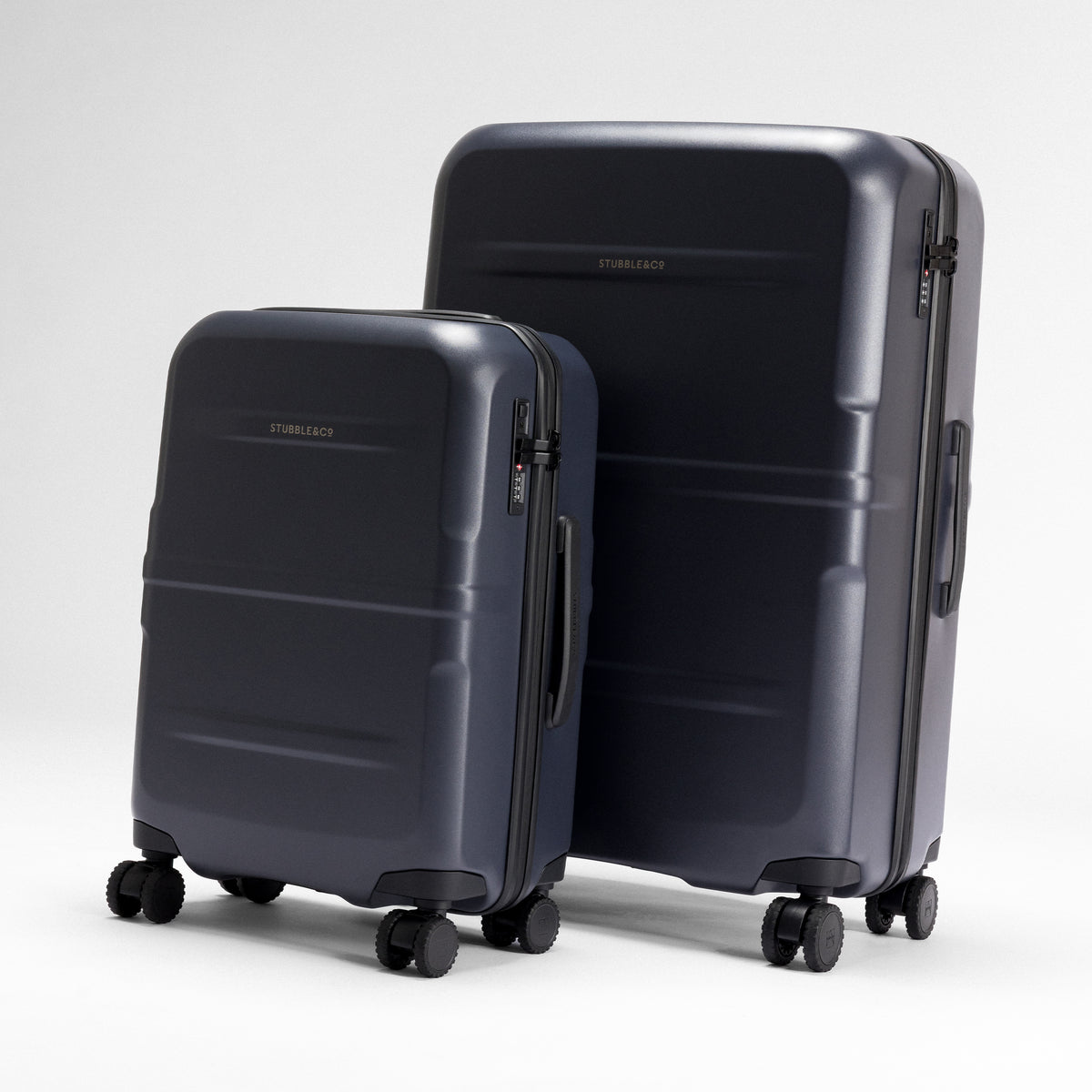 A studio shot of the Midnight Blue Hardshell suitcases standing next to eachother