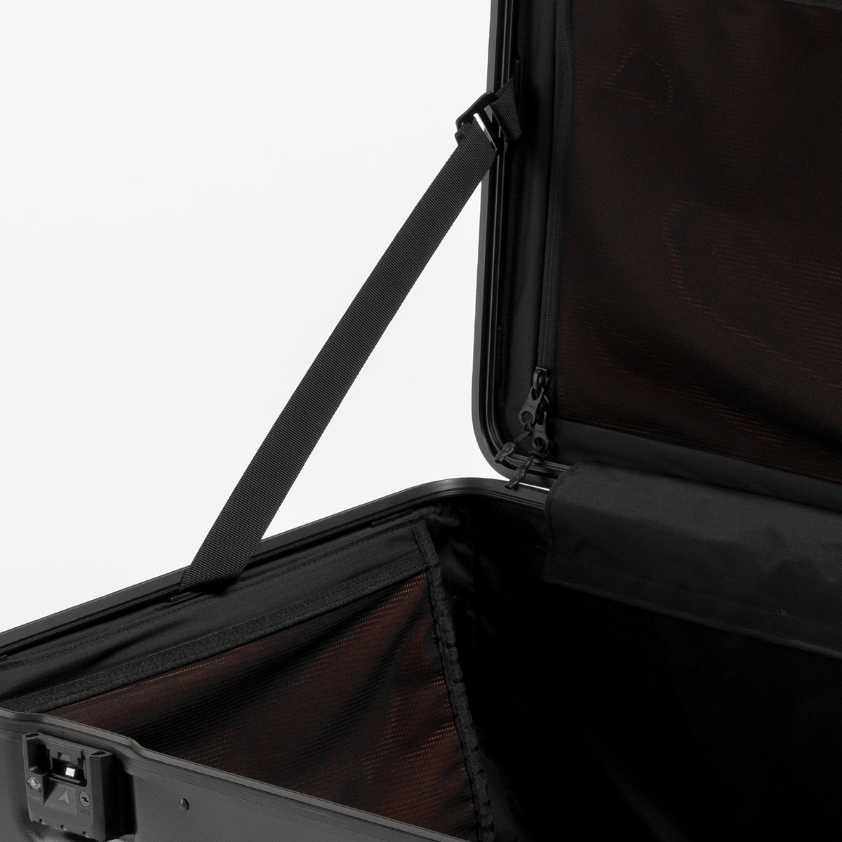 Close-up of an open black hard-shell suitcase with a black zipper and dark interior lining, shown against a plain light background.