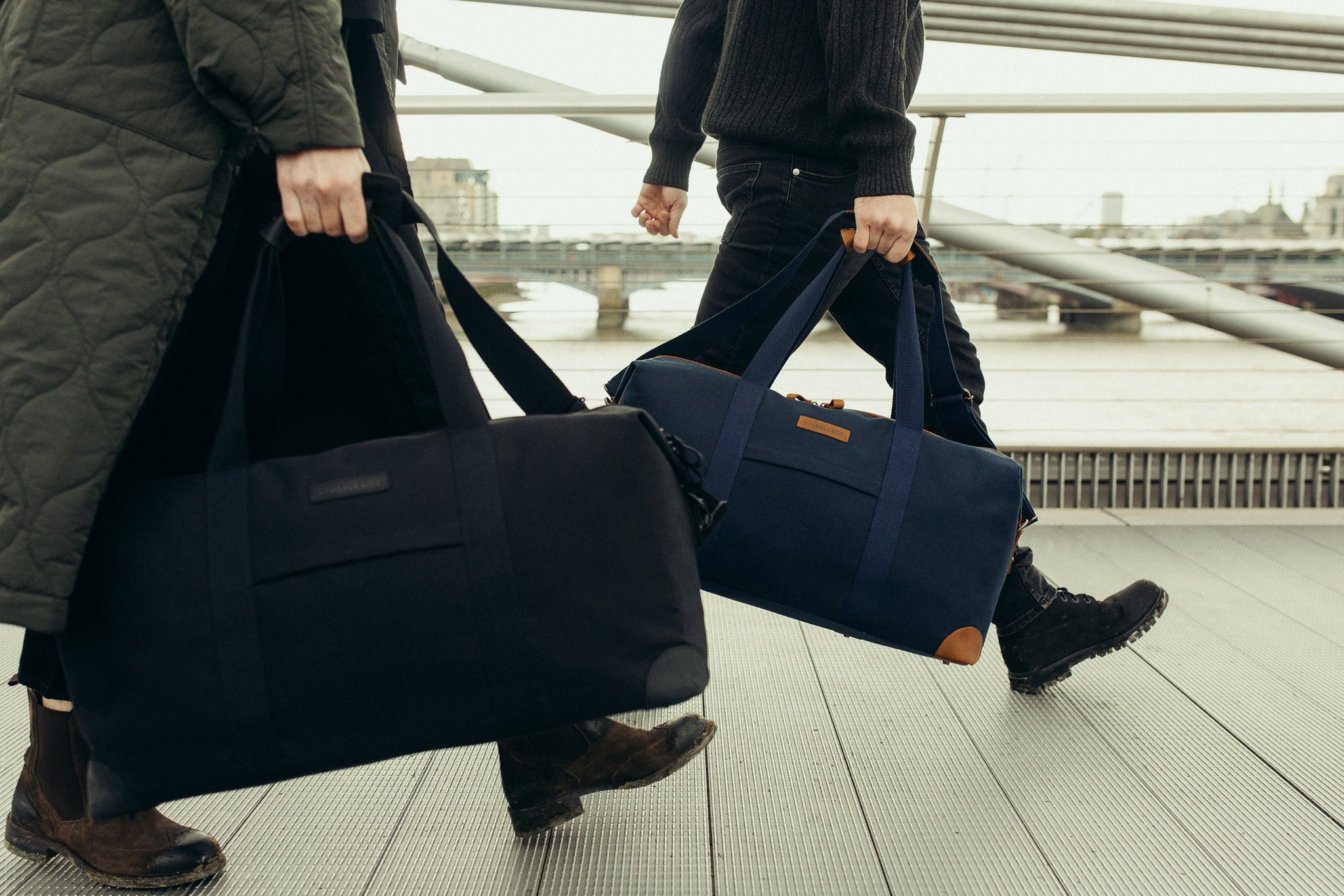 Two people carrying holdall duffle bags
