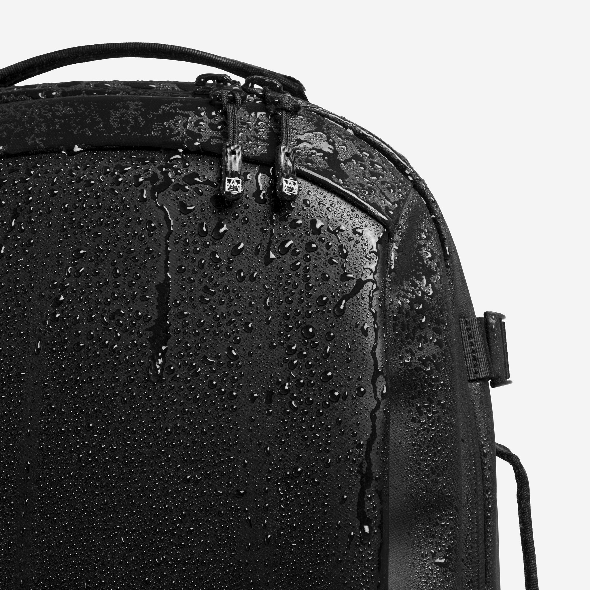 A studio shot of the waterproof material on the Hybrid Backpack 20L in All Black