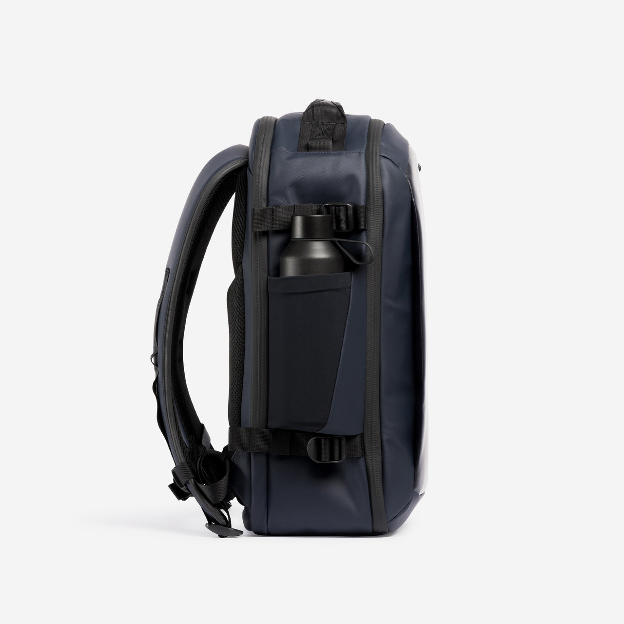 A studio shot of the side bottle pocket on a Hybrid Backpack 20L in Midnight Blue
