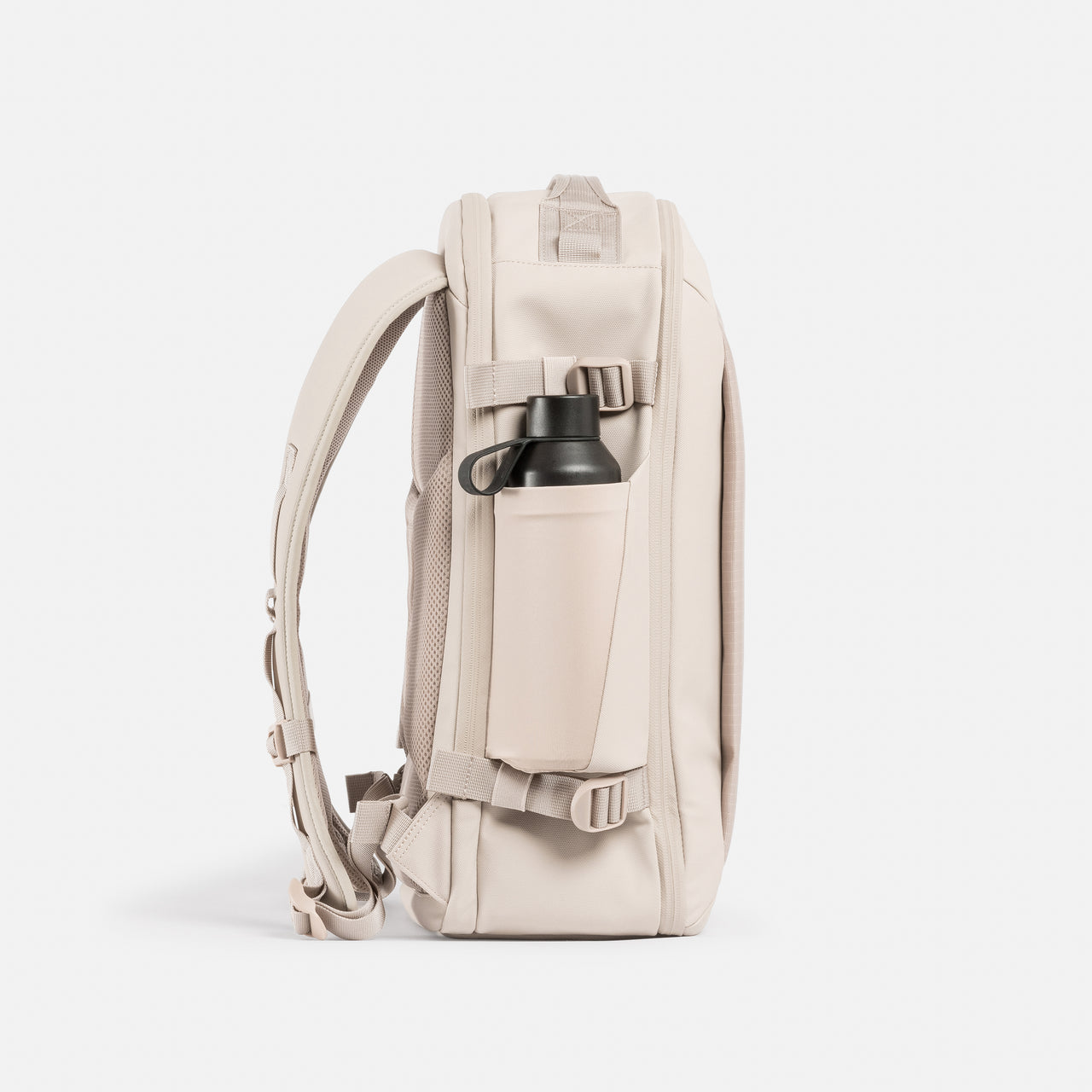 A studio shot of the elasticated bottle pocket on the side of the Tonal Sand Hybrid Backpack 20L