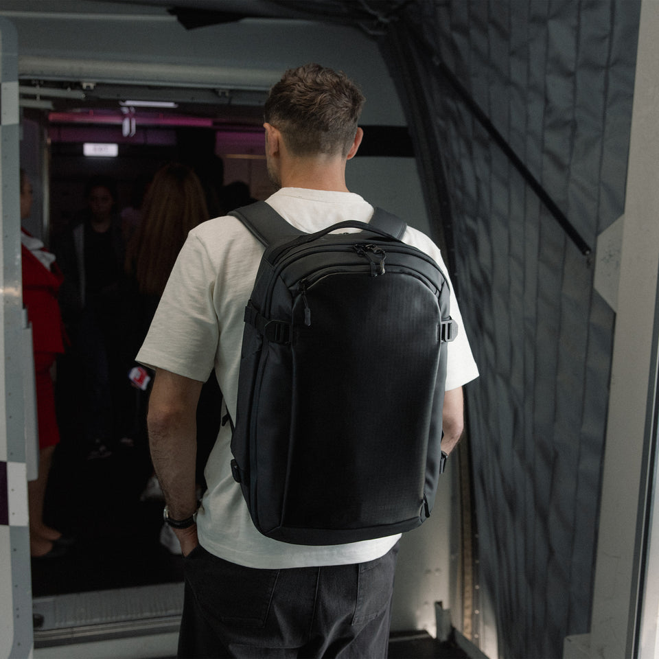 A man boarding a plane wearing a Hybrid Backpack on his back