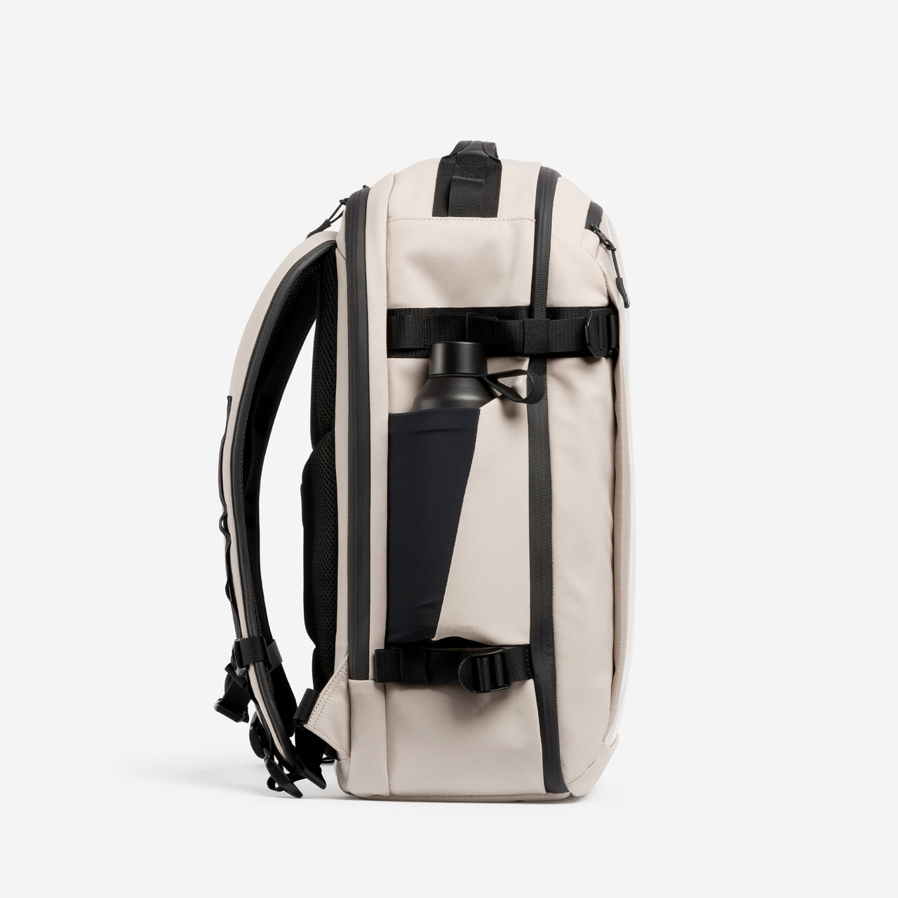 A studio shot of the side bottle pocket on the Hybrid Backpack 30L in Sand